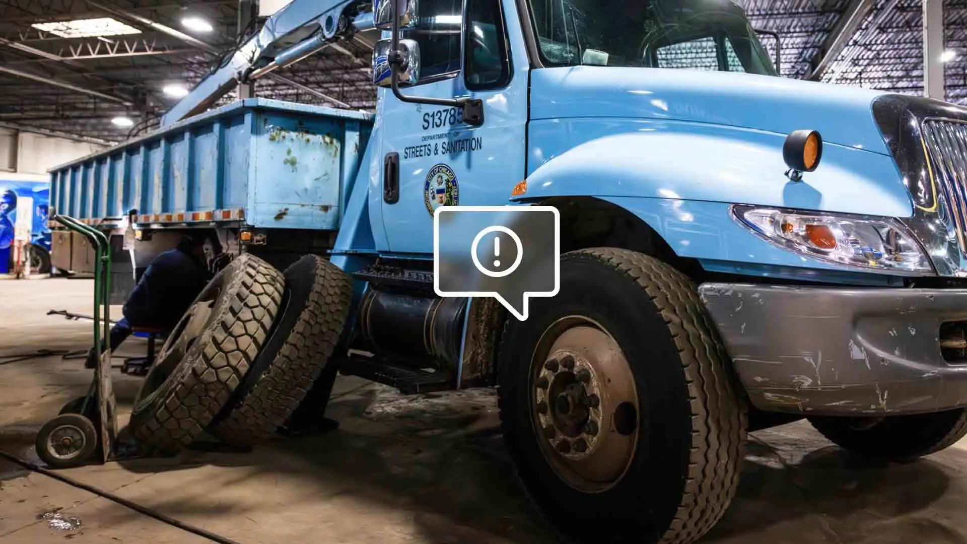 A heavy duty truck with a warning symbol on its tire.
