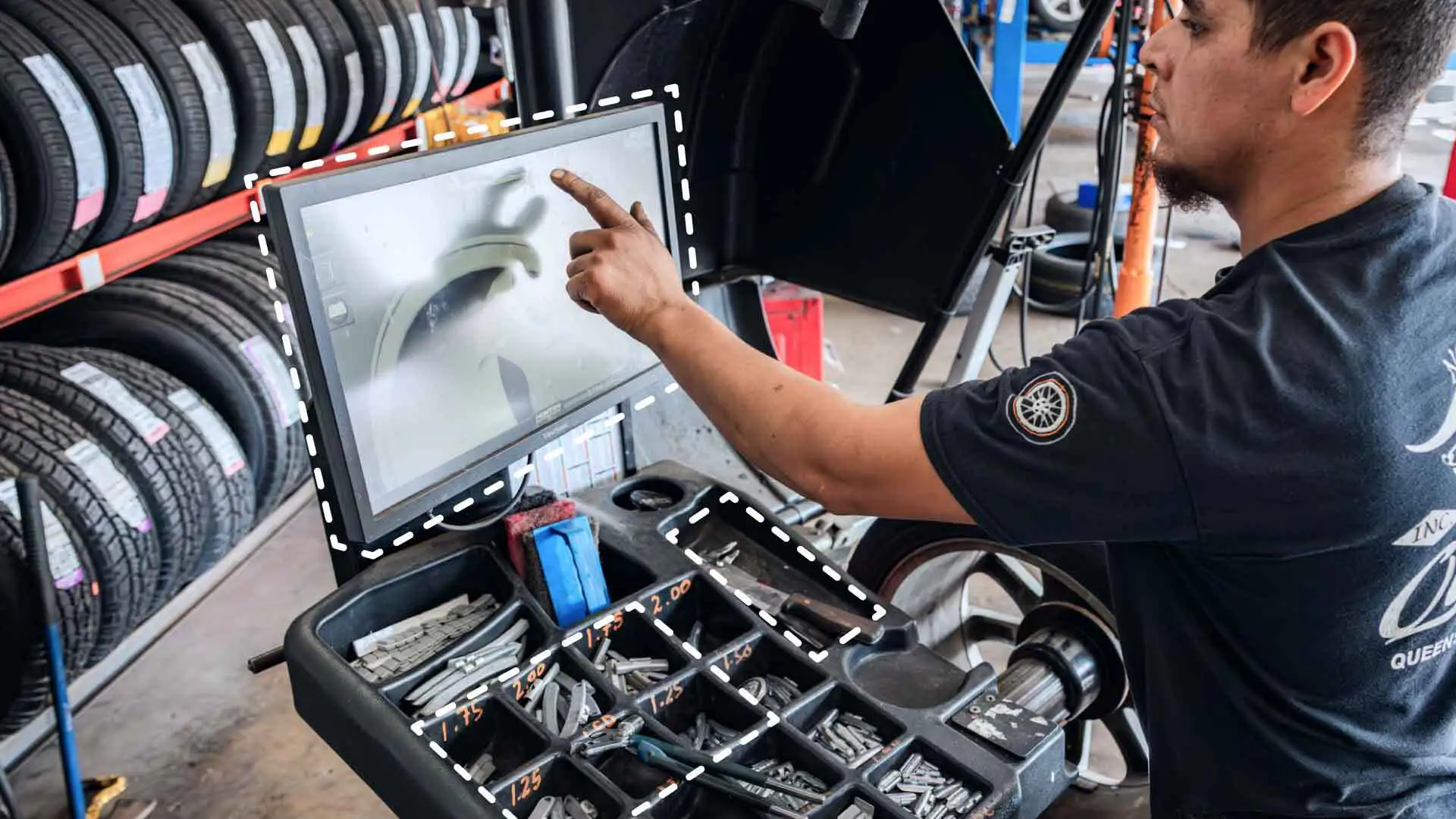 An auto service technician looking at a computer screen.