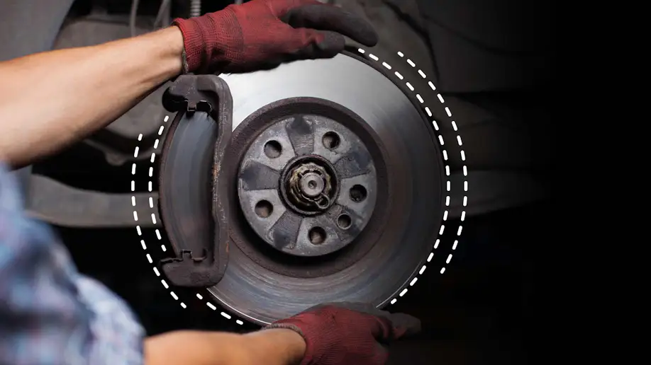 An automotive technician working on vehicle brakes.