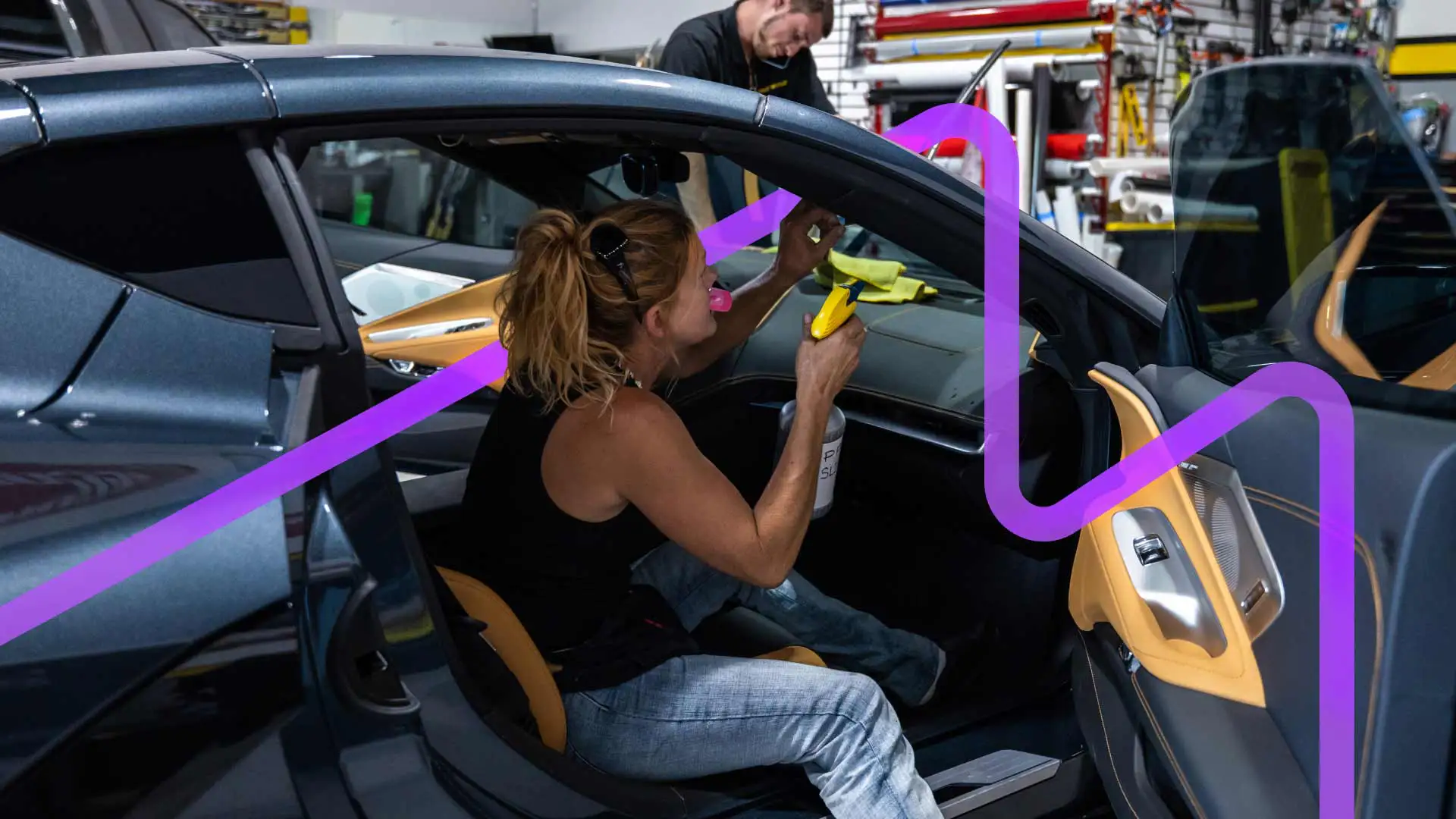 Auto technician performing an interior detailing task on a vehicle.