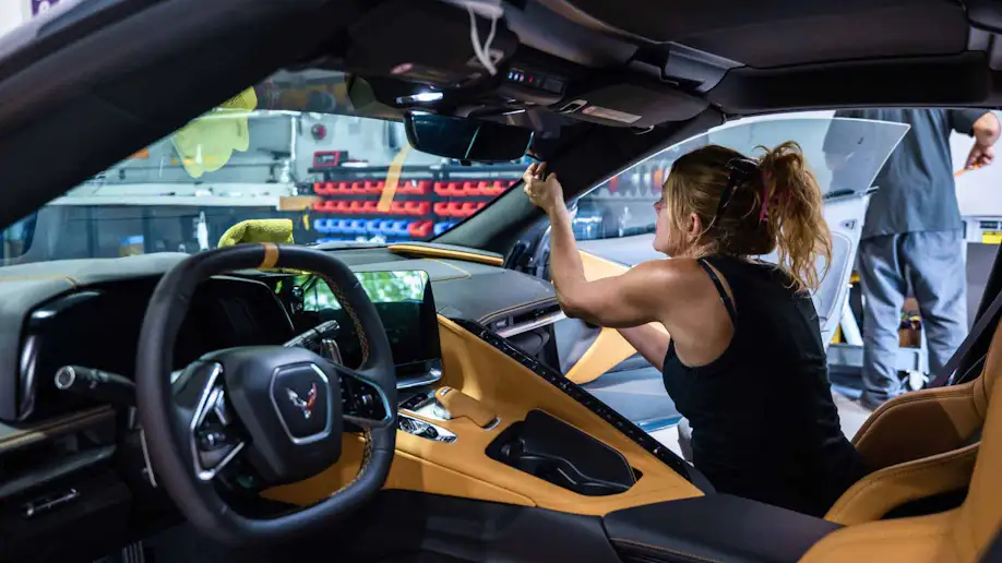 An auto detailer working on a vehicles interior.