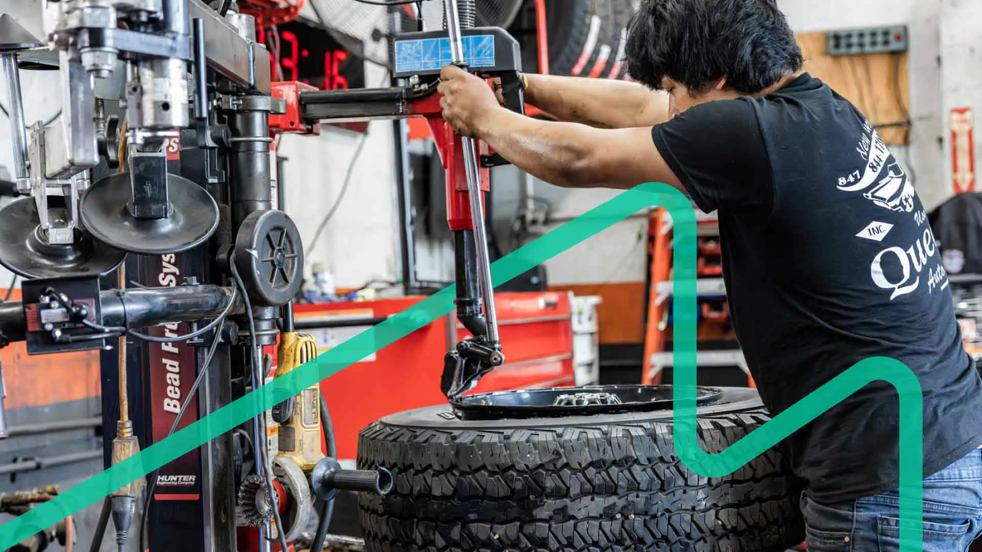 An auto repair technician removing a tire from a vehicle rim.