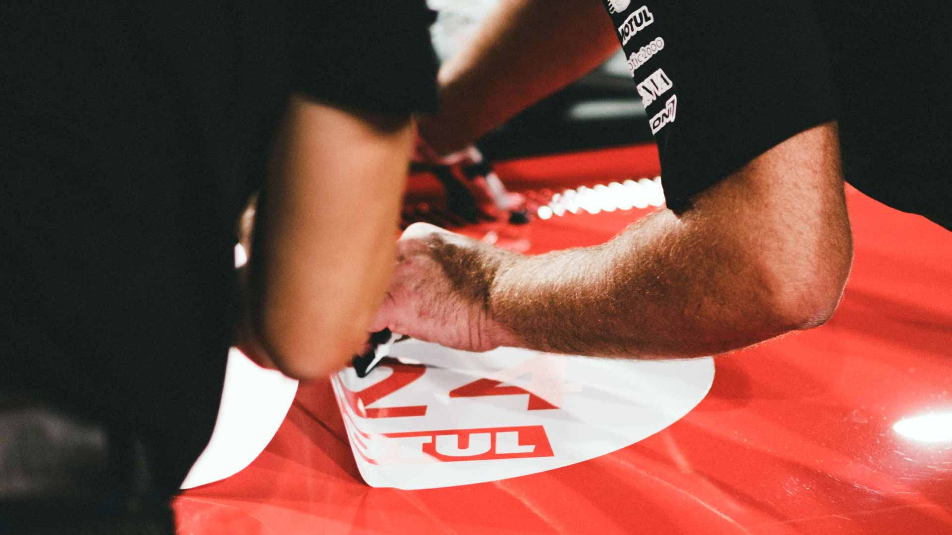 An auto detailer removing a vehicle decal.