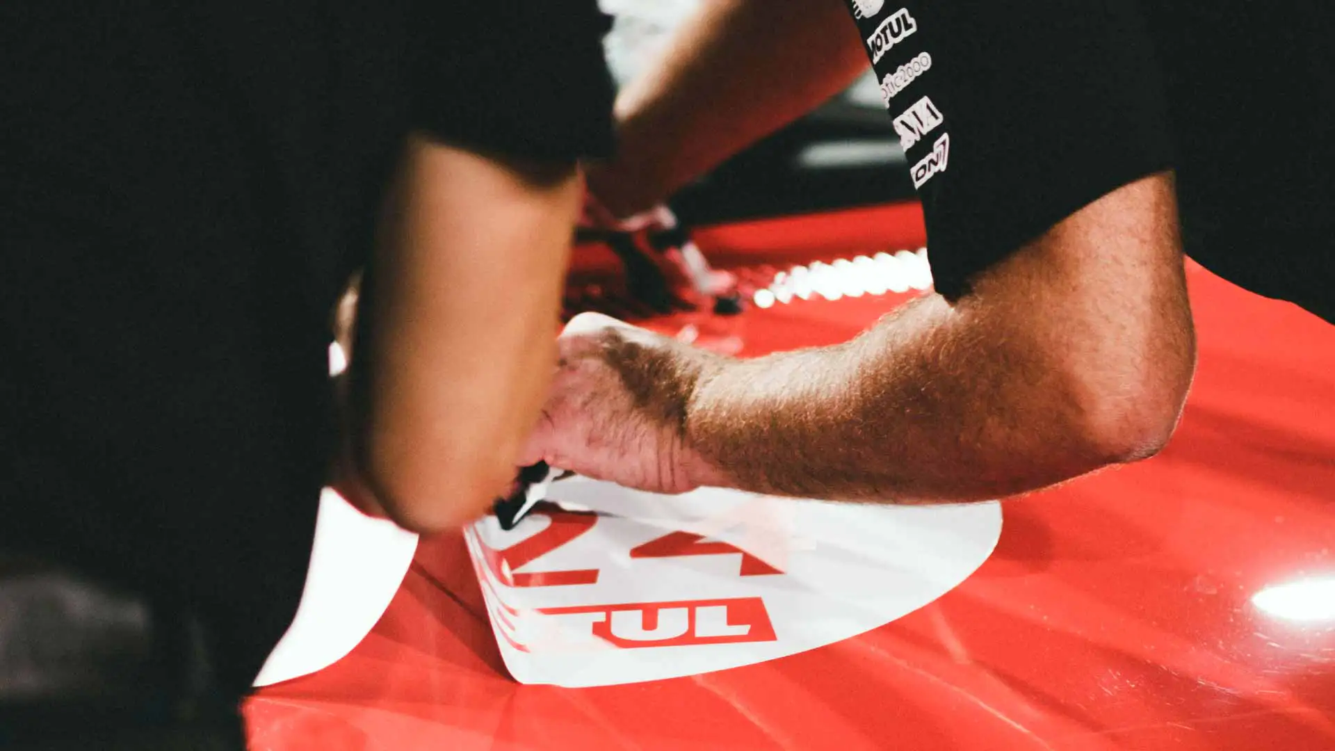 An auto detailer removing a vehicle decal.