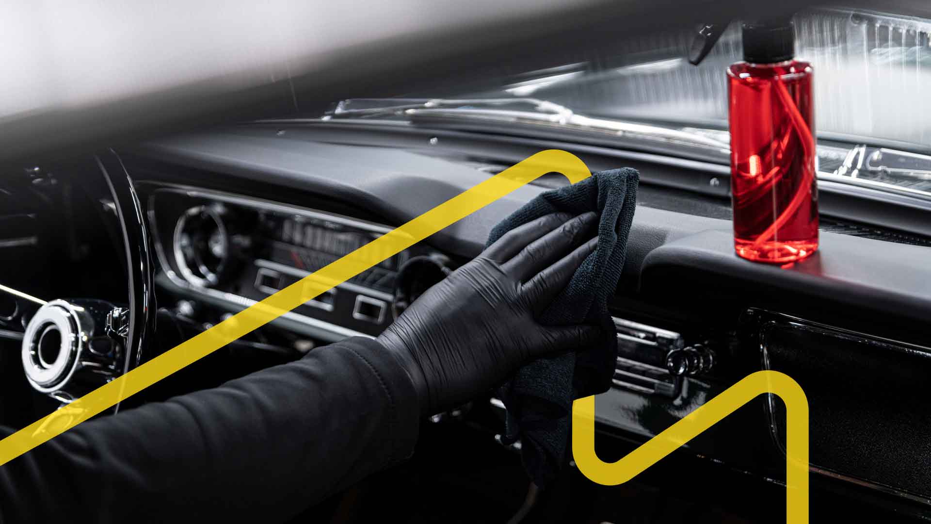 An auto detailer cleaning the inside of a vehicle.