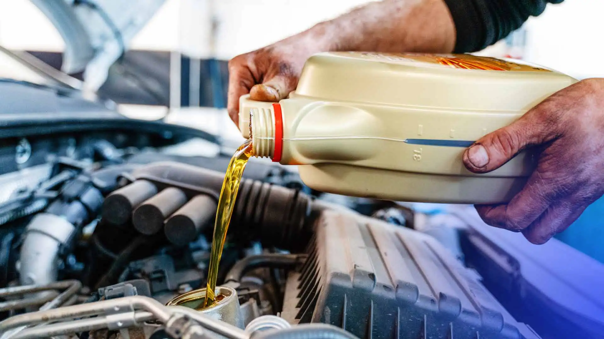 A quick lube technician using high milage oil for an oil change.