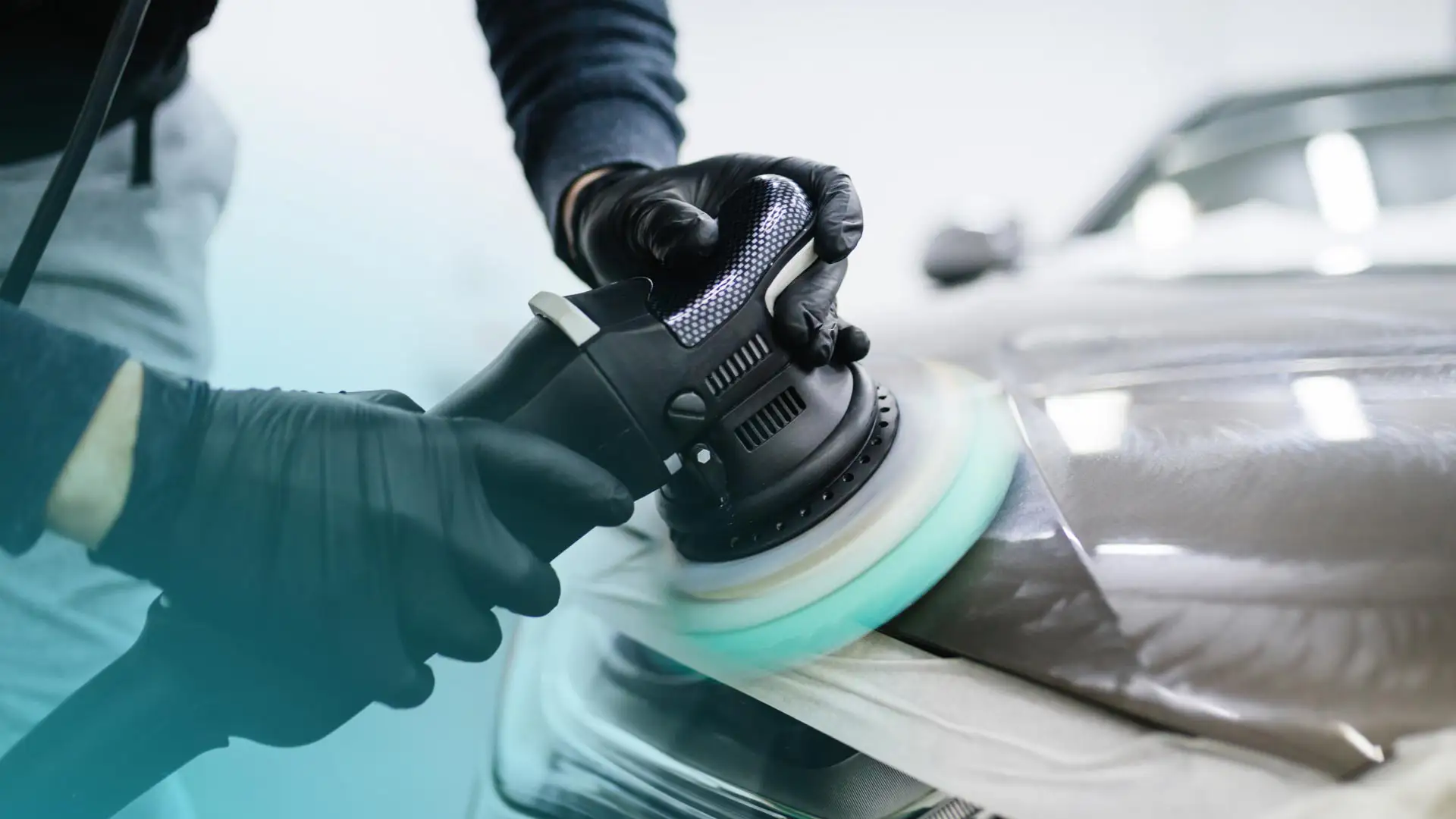 An auto detailer buffing a vehicle's exterior.