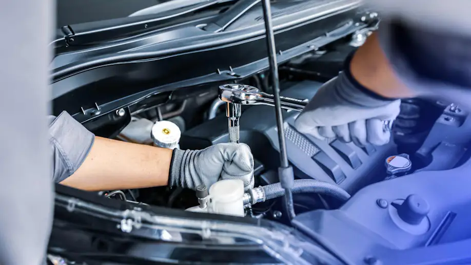 Two mechanics working on a vehicle.