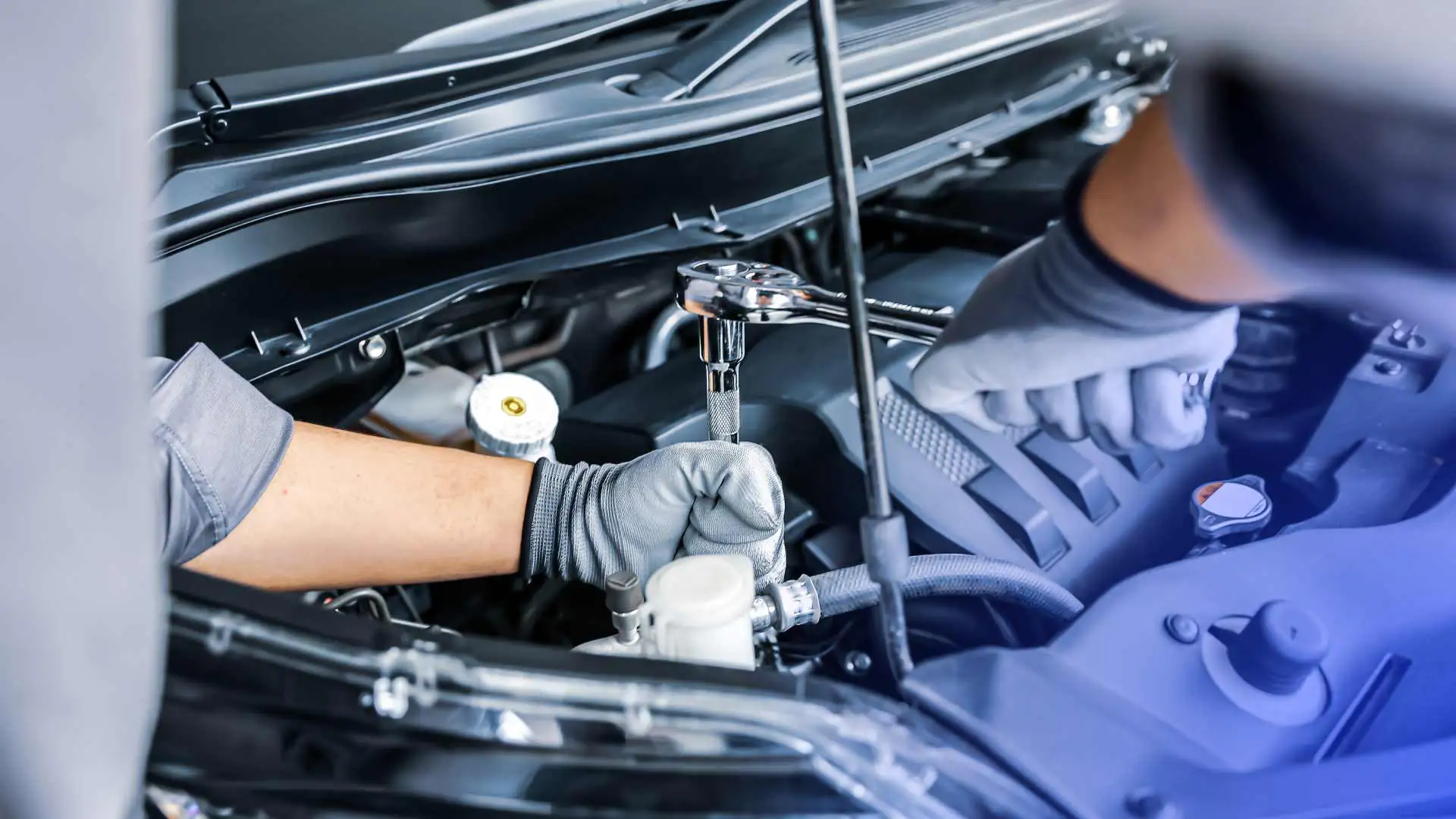 Two mechanics working on a vehicle.