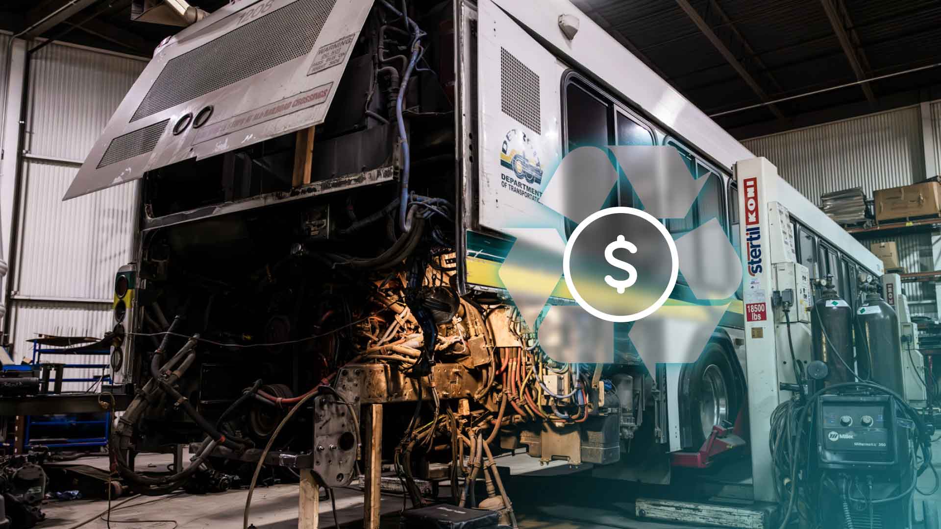 A commercial bus being worked on by mechanics.