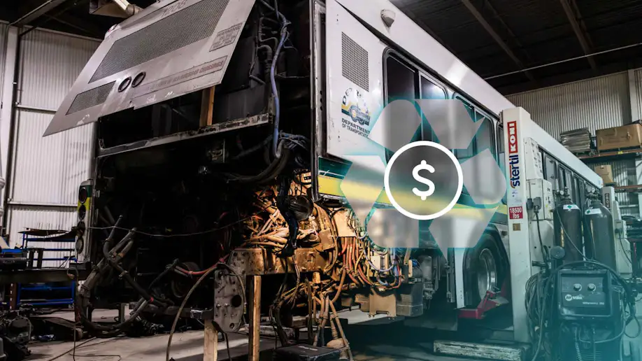 A commercial bus being worked on by mechanics.