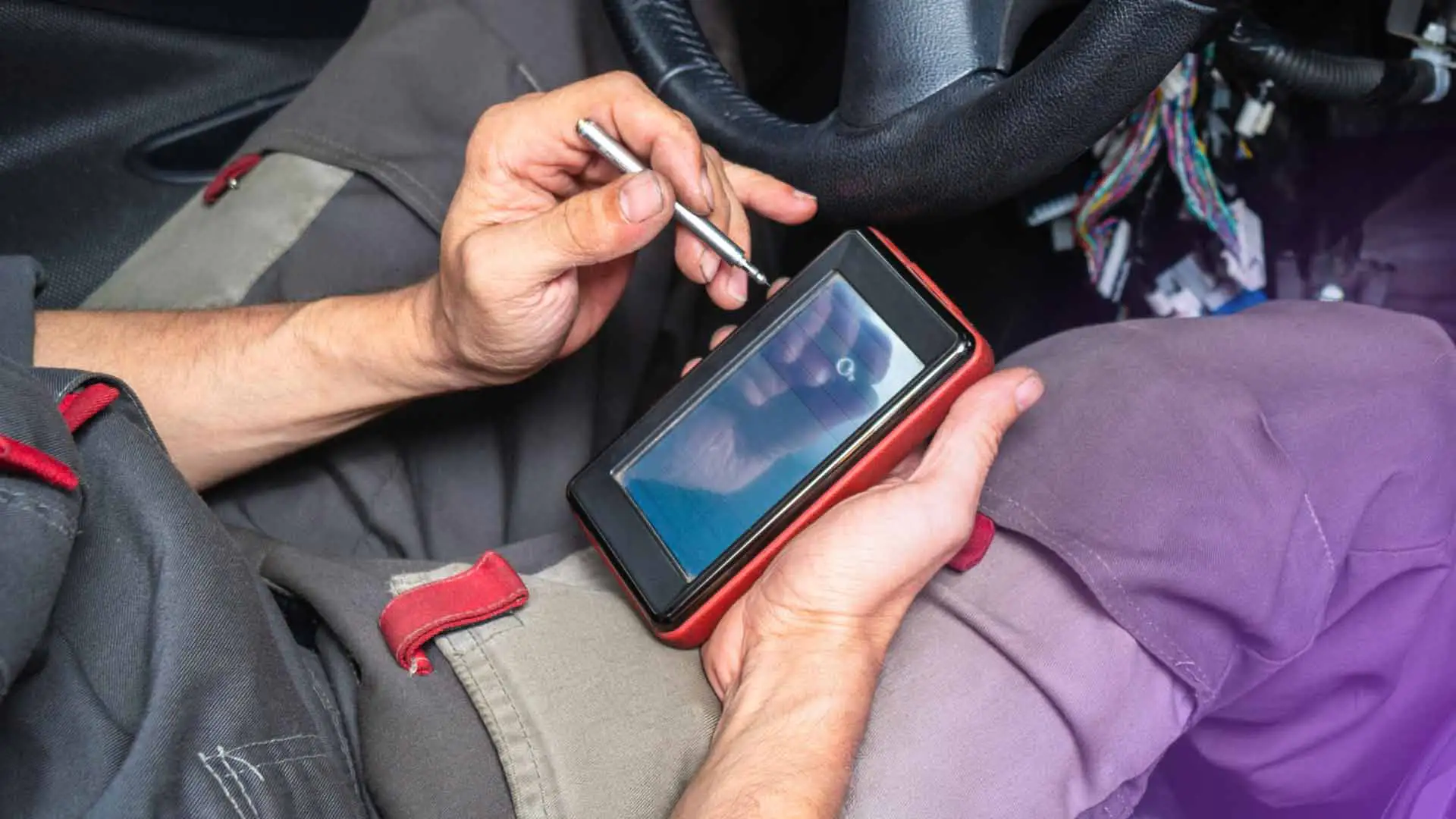 An auto repair technician using an OBD2 scanner.