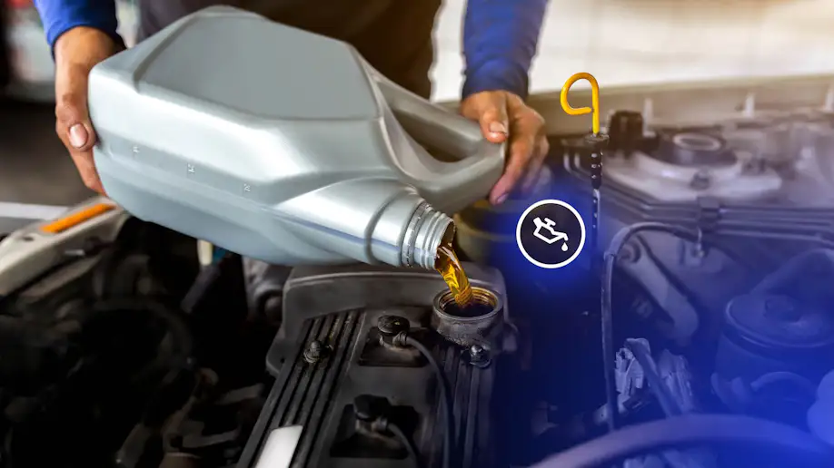 Motor oil being added to a vehicle's engine at a quick lube shop.