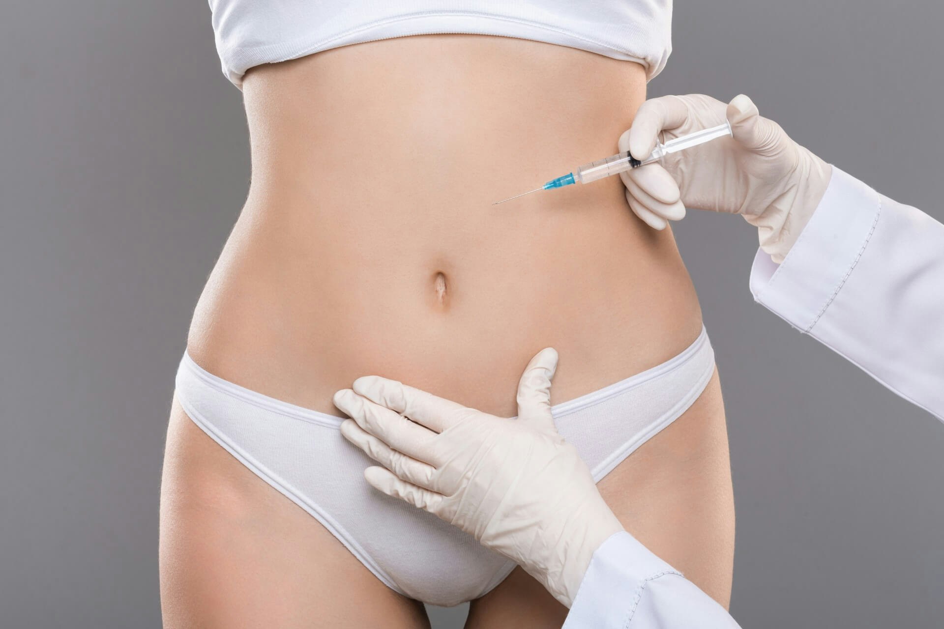Doctor applying injection to woman's belly