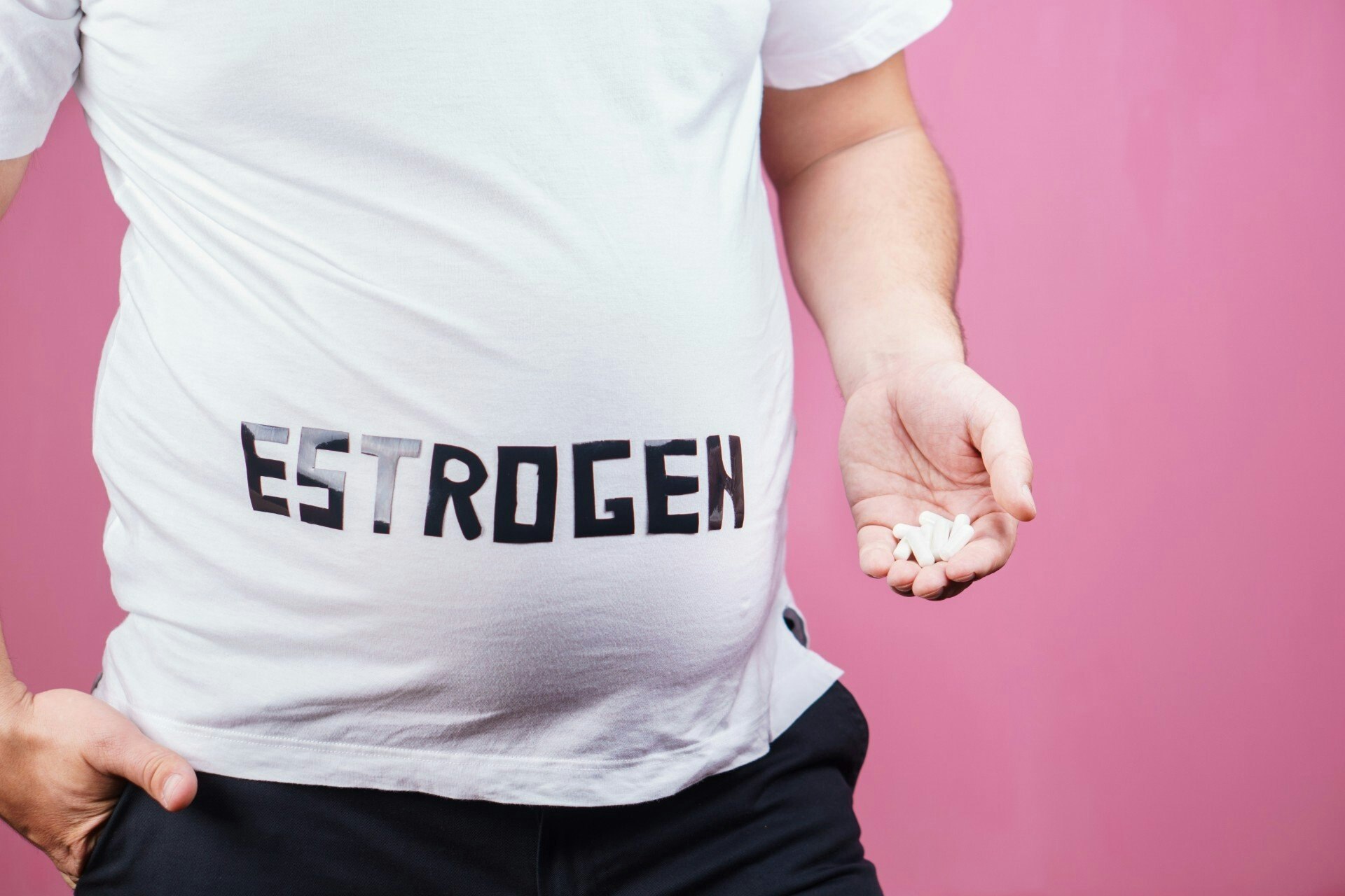 man with a prominent belly and pills in his hand
