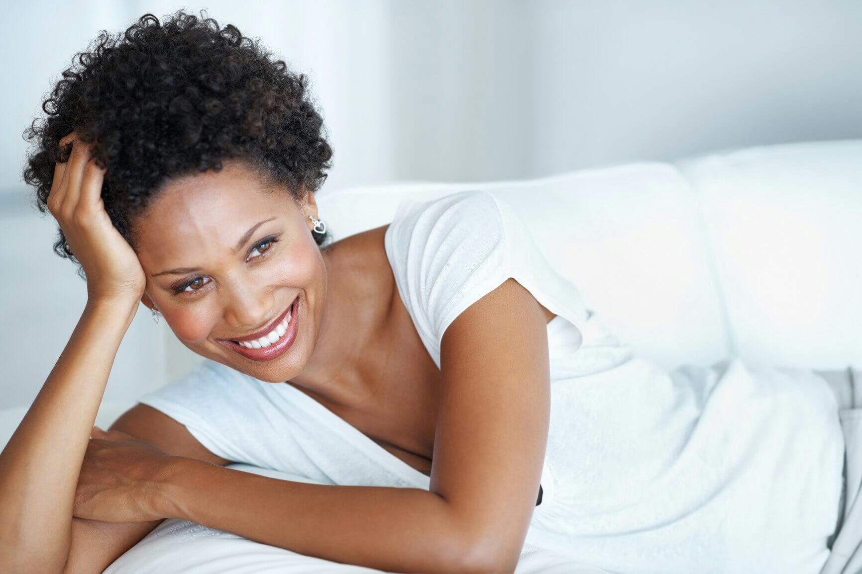 woman smiling on white sofa