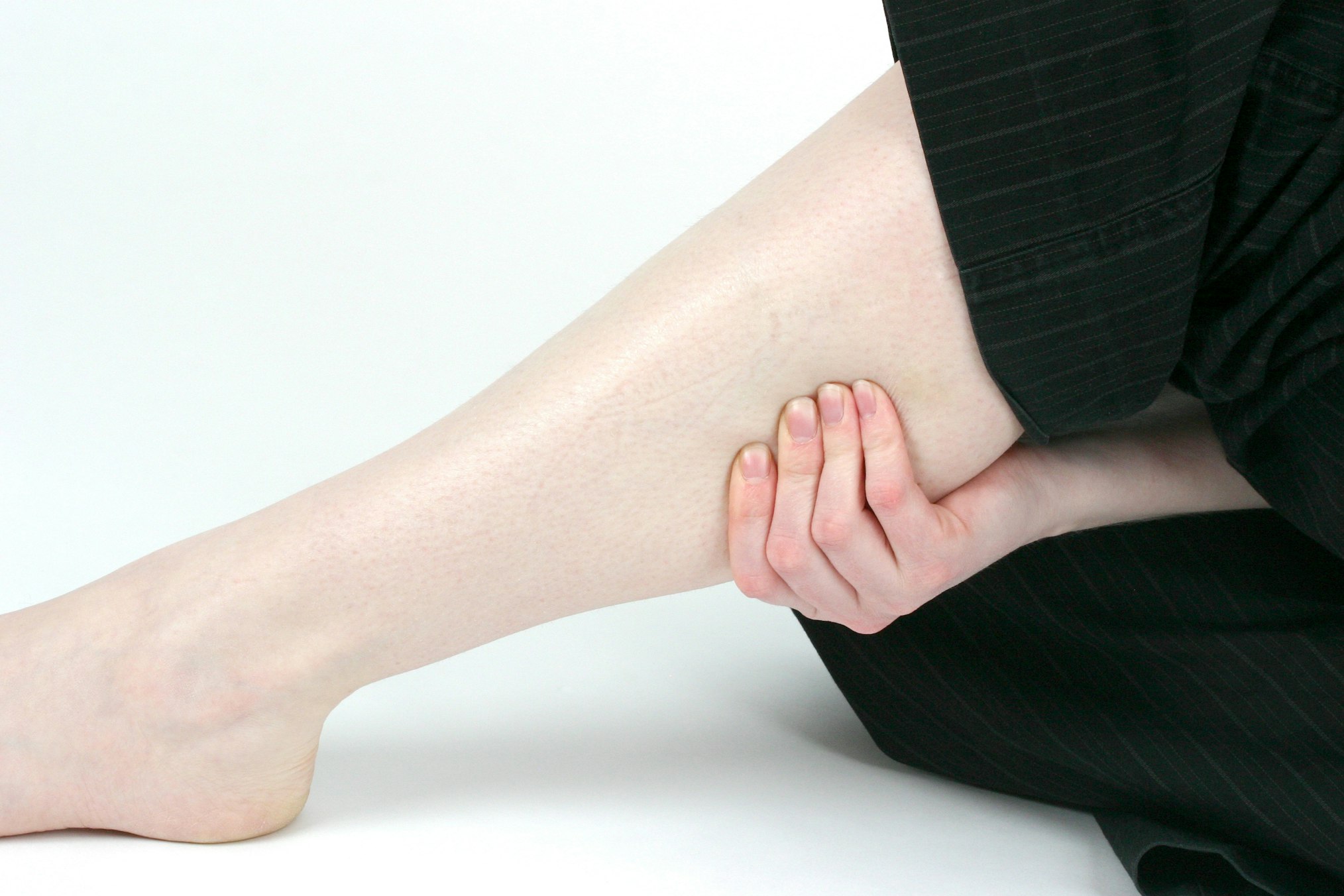 woman holding her calf and leg muscle