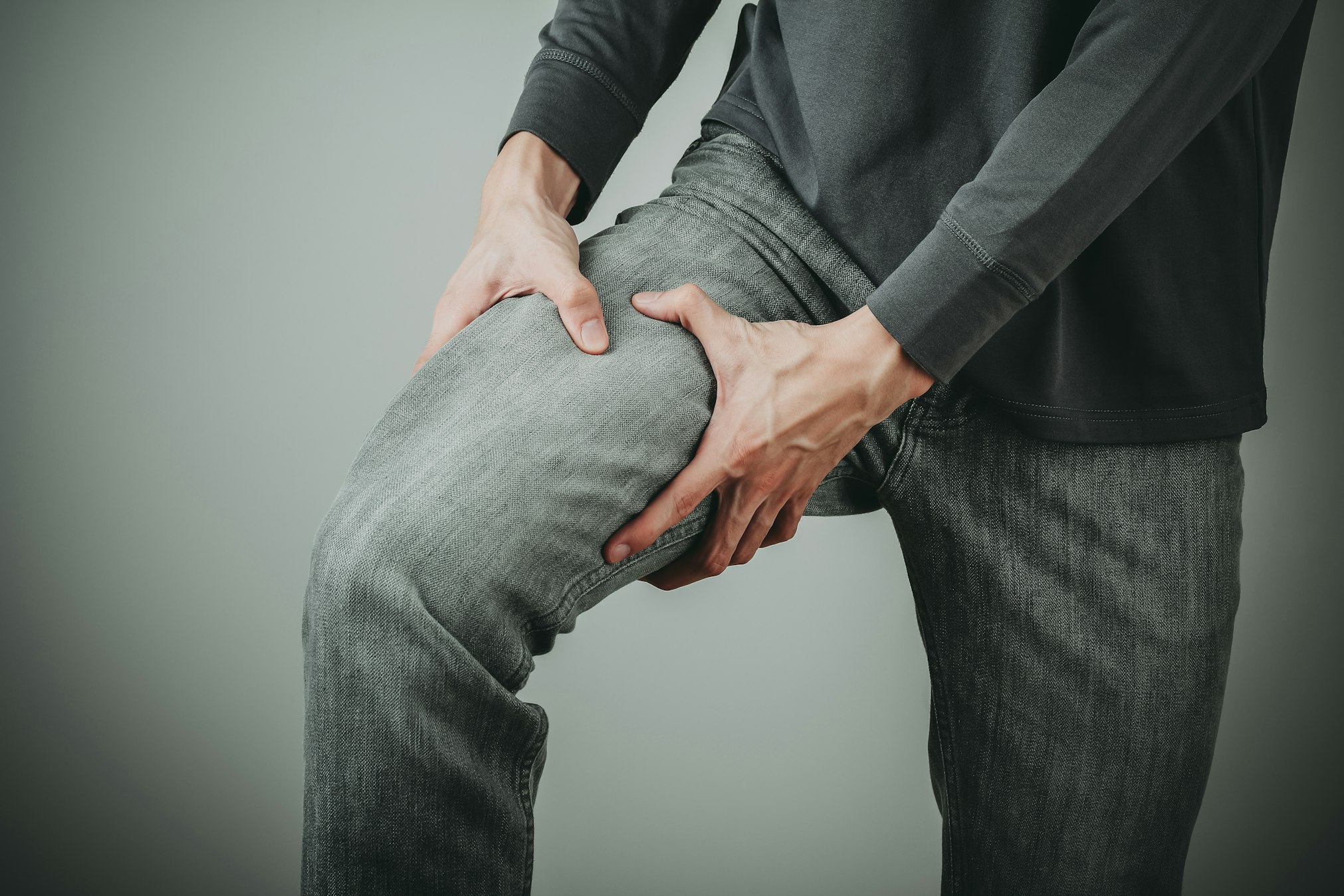 man holding thigh in jeans