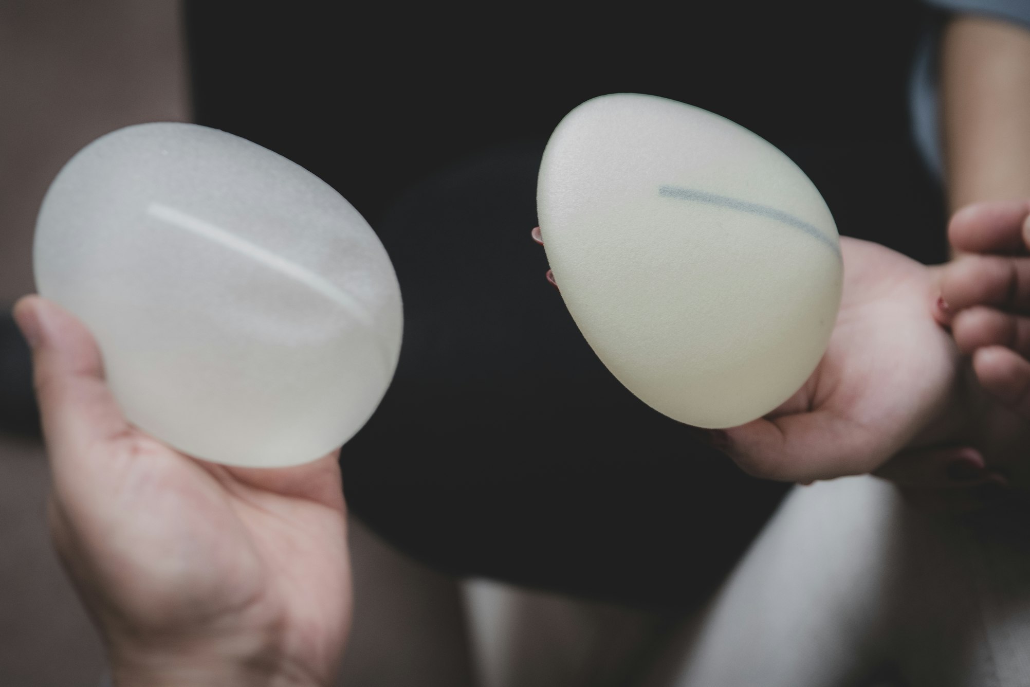 Plastic surgeon and patient discuss choice of breast implants for breast augmentation.