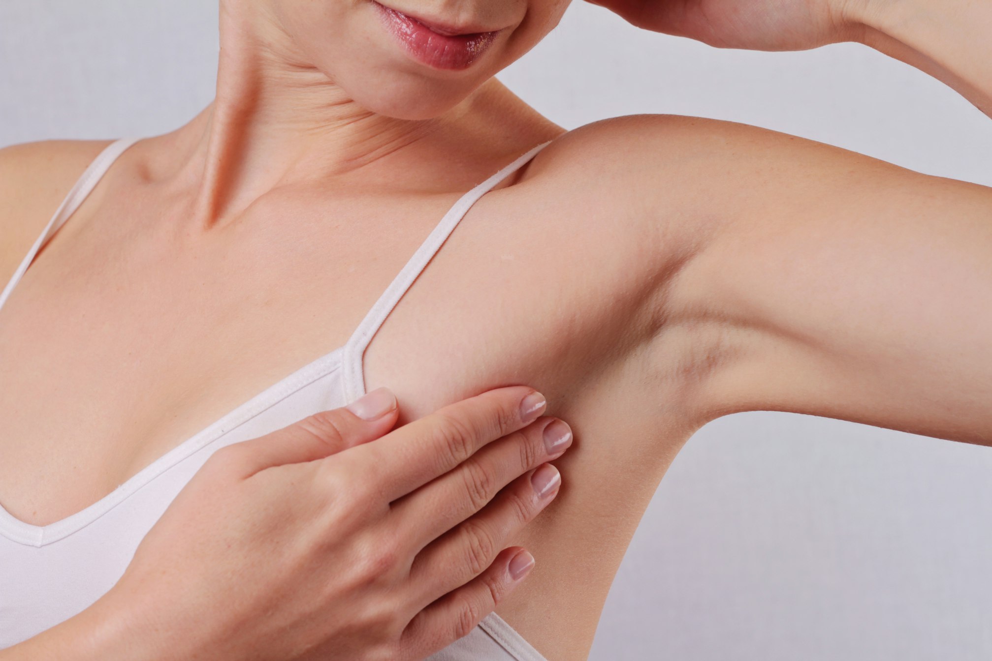 Young woman holding her arms up and showing underarms, armpit, ideal smooth clear skin