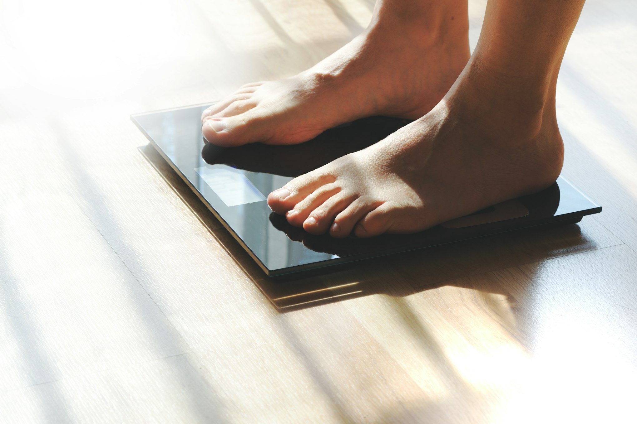 Feet on a scale for weight control after bathroom.