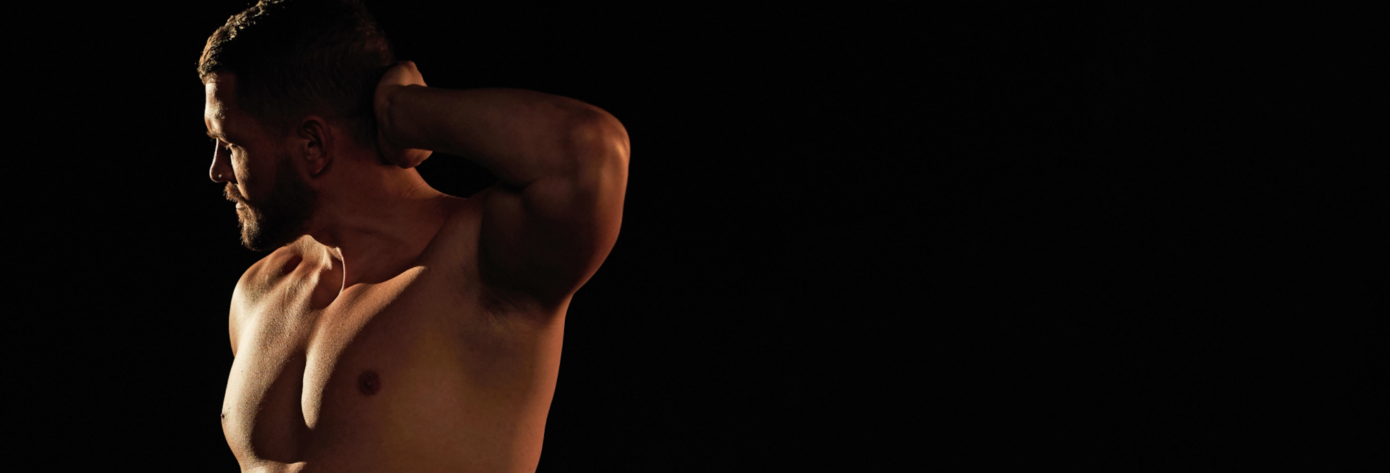 shirtless man with hand on head