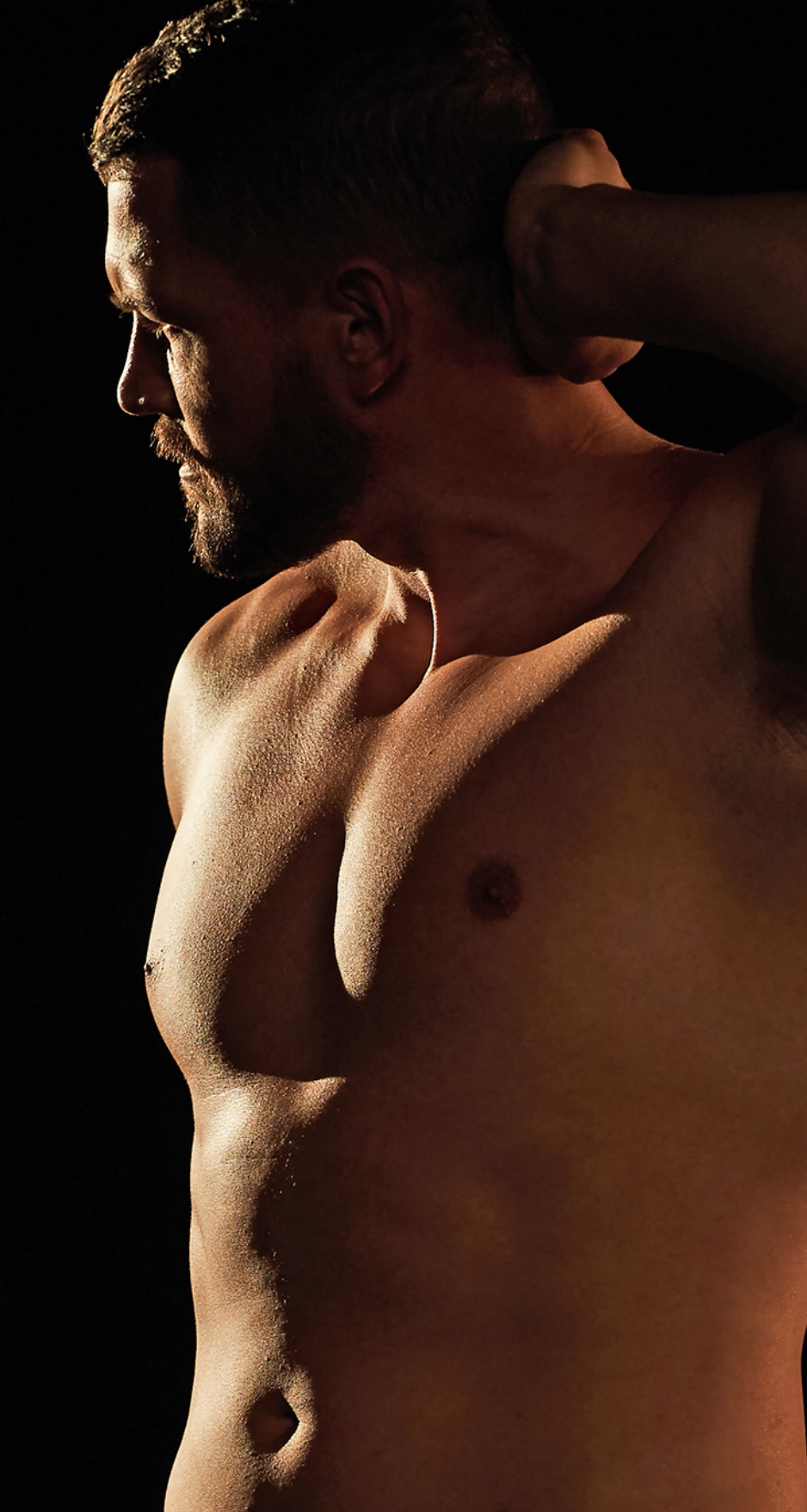 shirtless man with hand on head