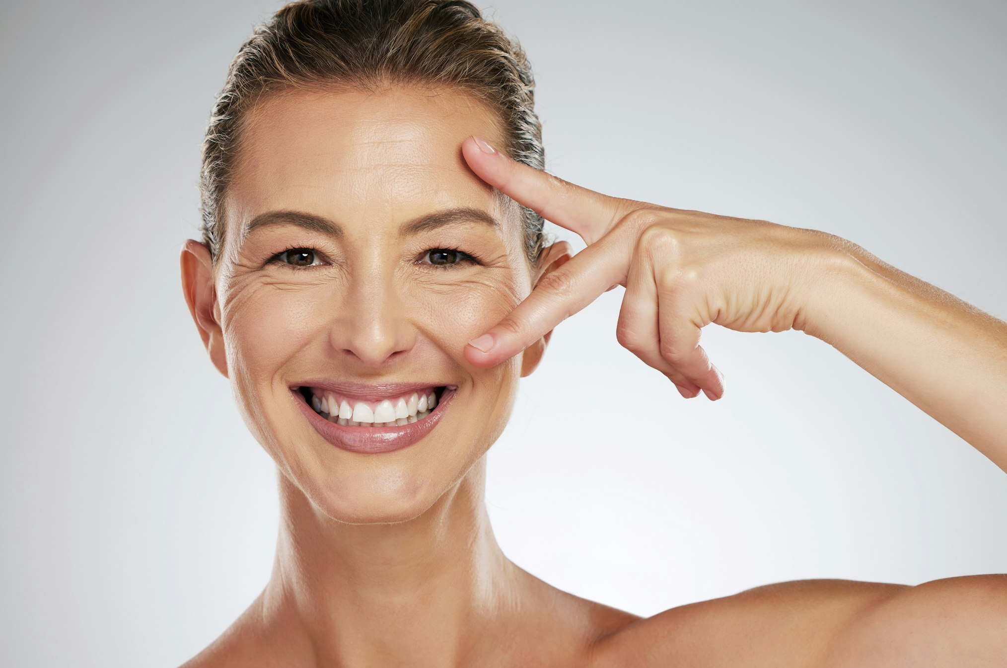 Skincare, beauty and face of mature woman with anti aging product to reduce lines and wrinkles against grey mockup studio background