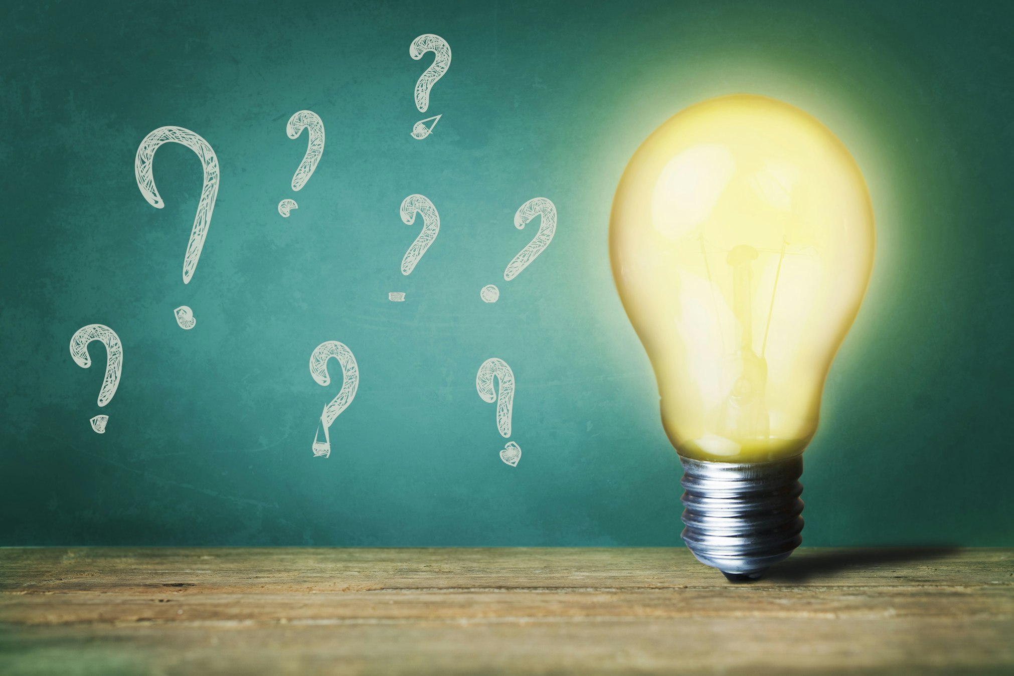 lit light bulb with question marks