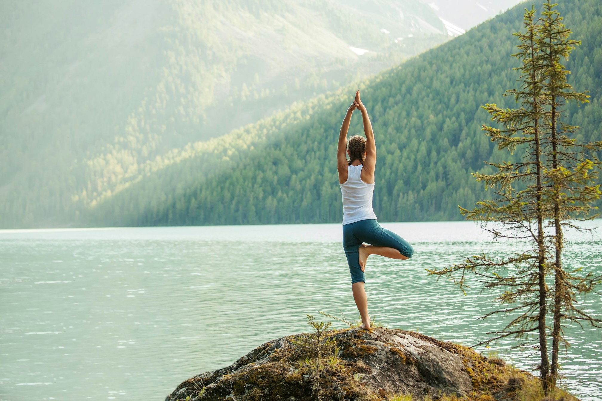 Woman doing yoga by lake