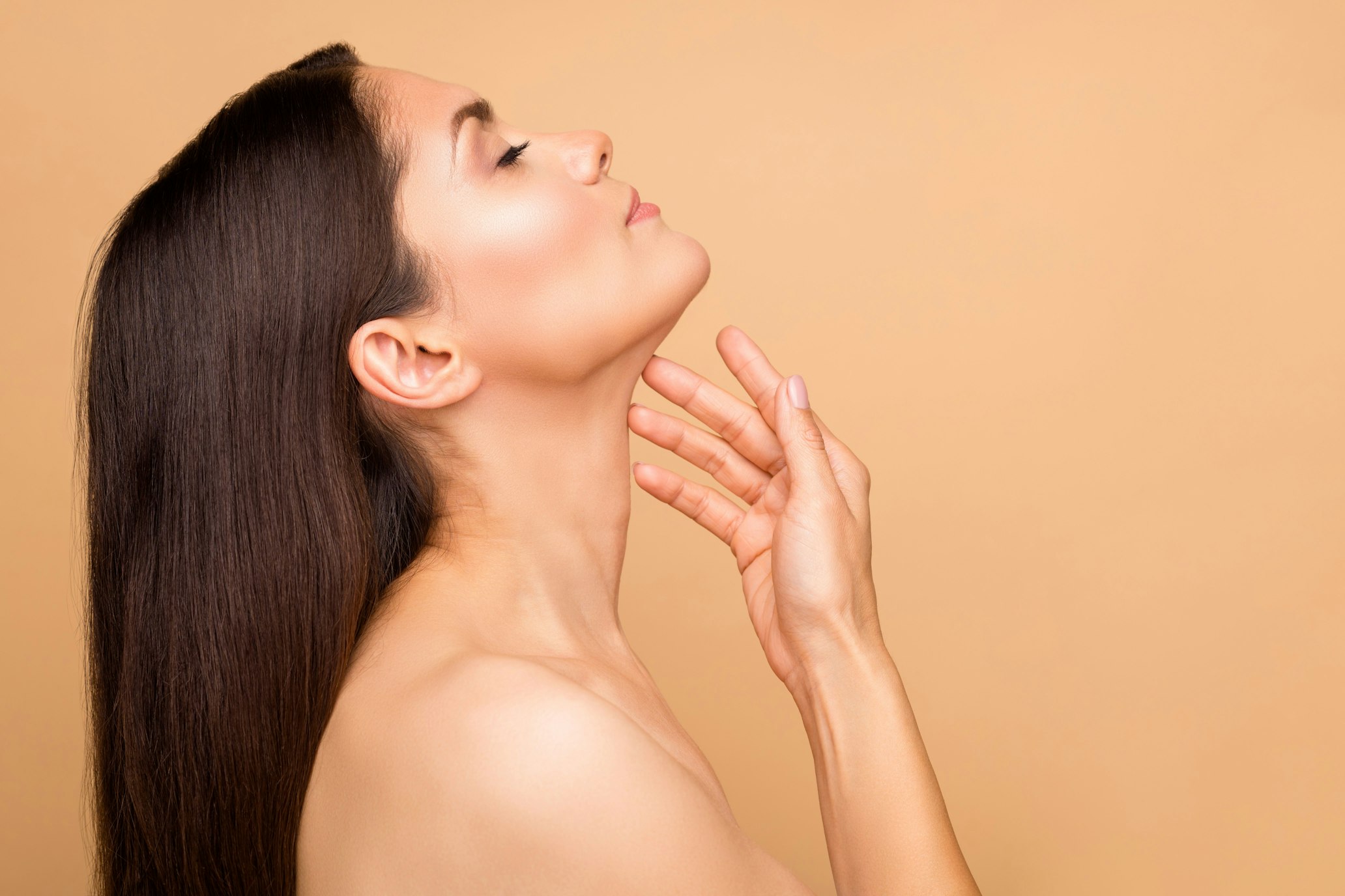Woman grazing chin with face pointed up