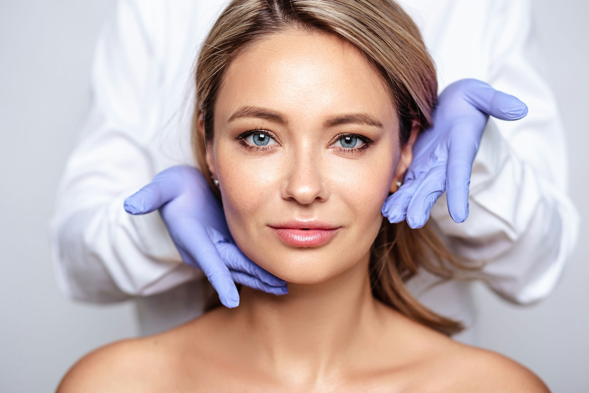 Doctor touching womans face with gloves