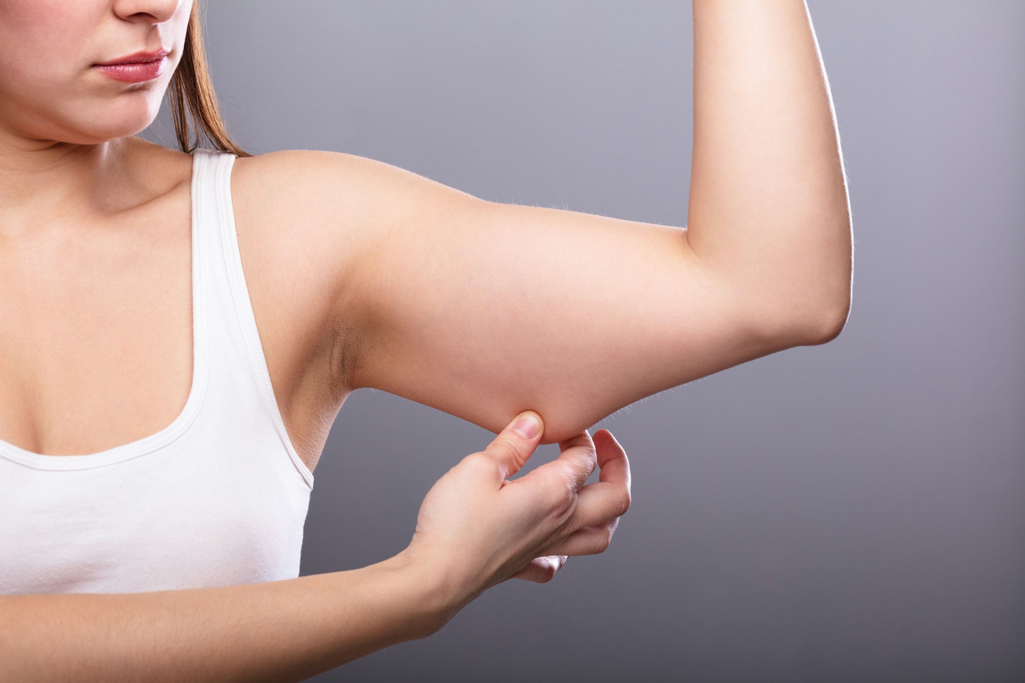woman grabbing underarm fat