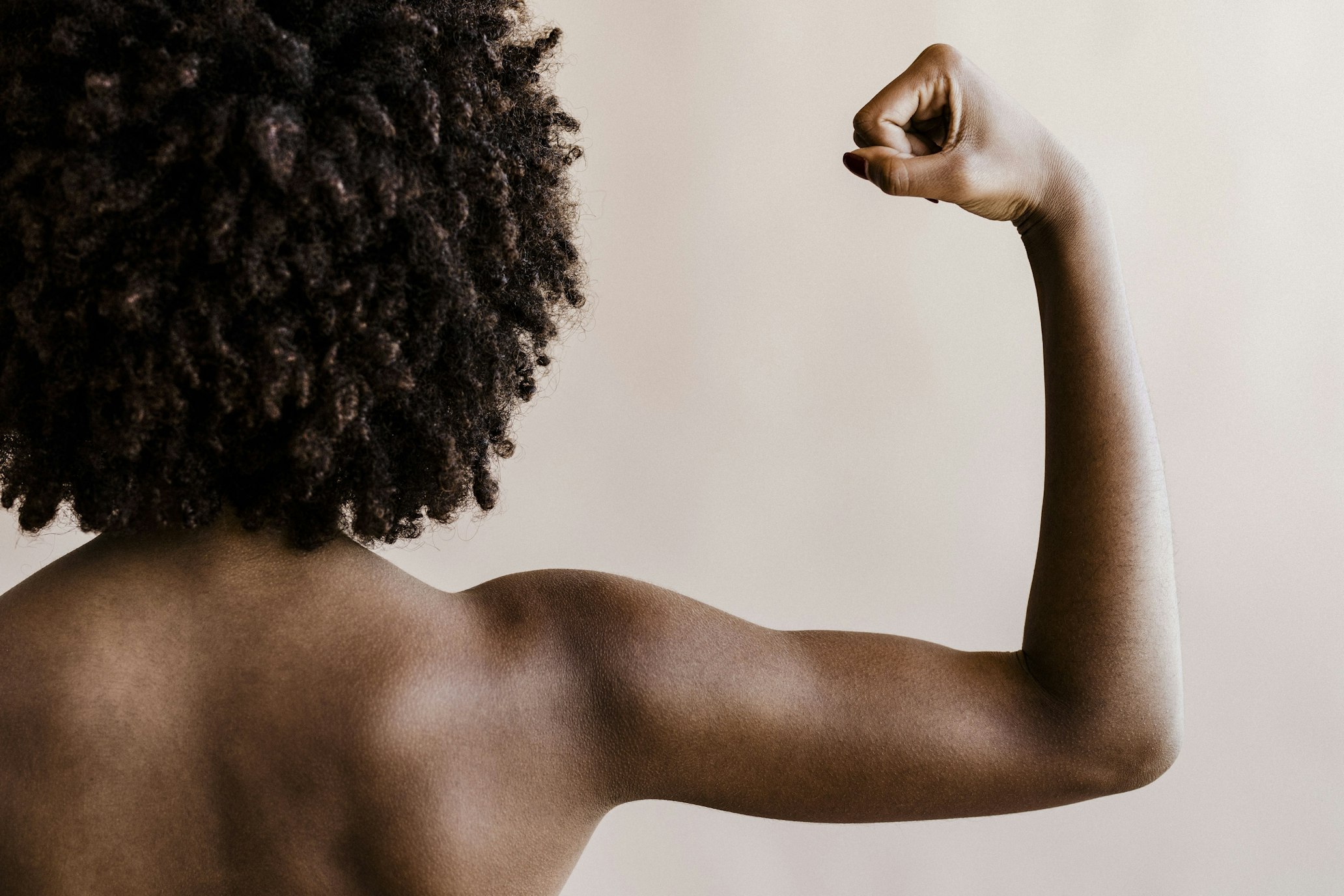 Black woman flexing one arm