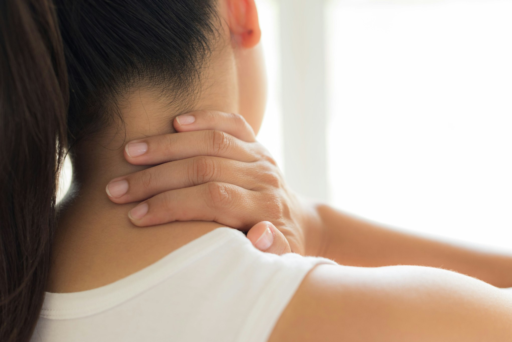 woman grabbing the back of her neck