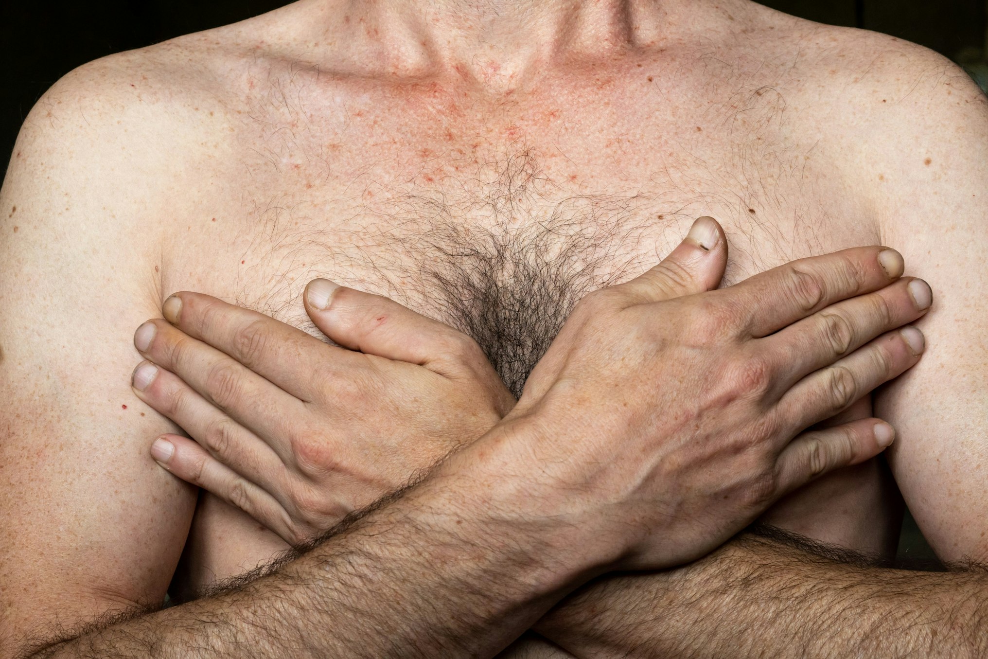 man hiding chest