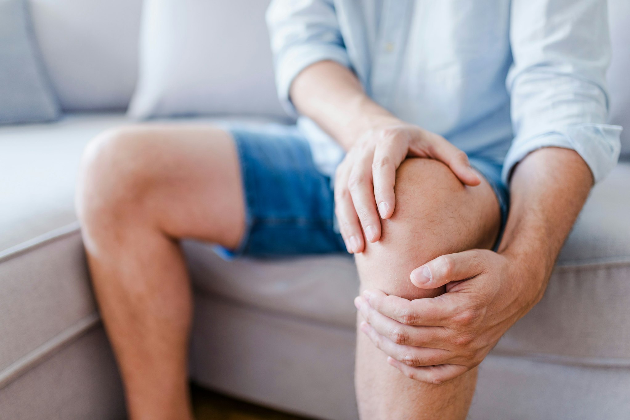 man rubbing his knee