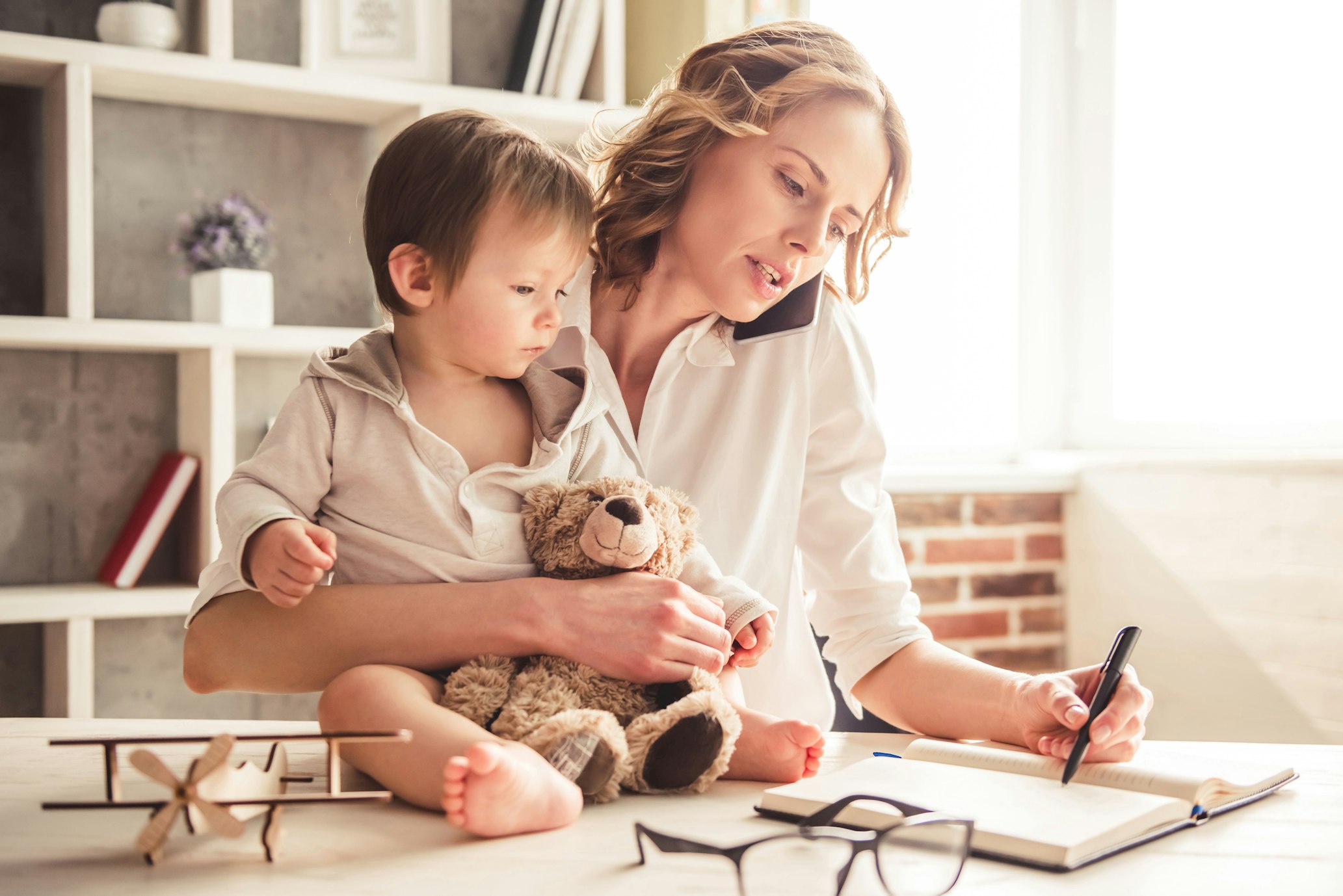 mother on phone holding child