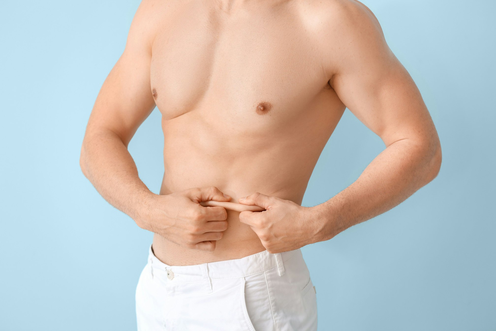 man pinching abdominal skin