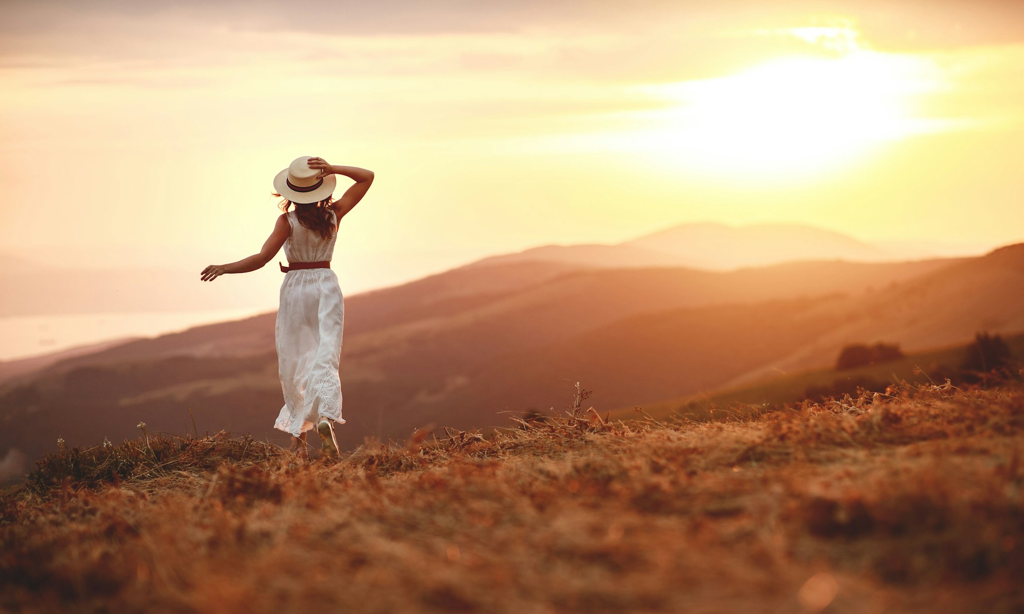woman facing the mountains at sunset