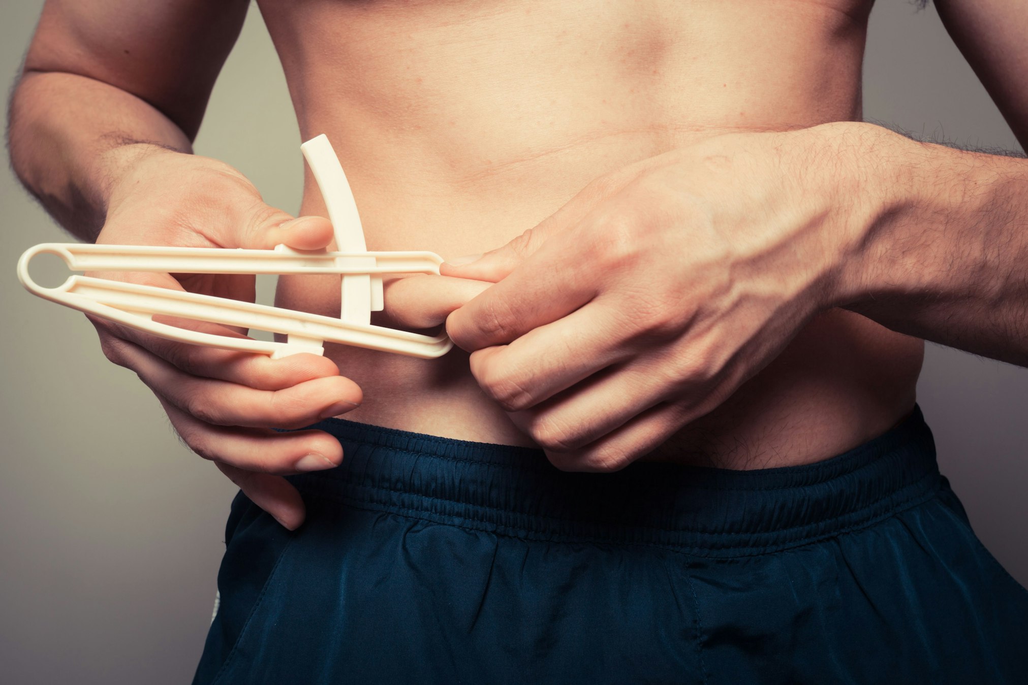 man measuring belly fat