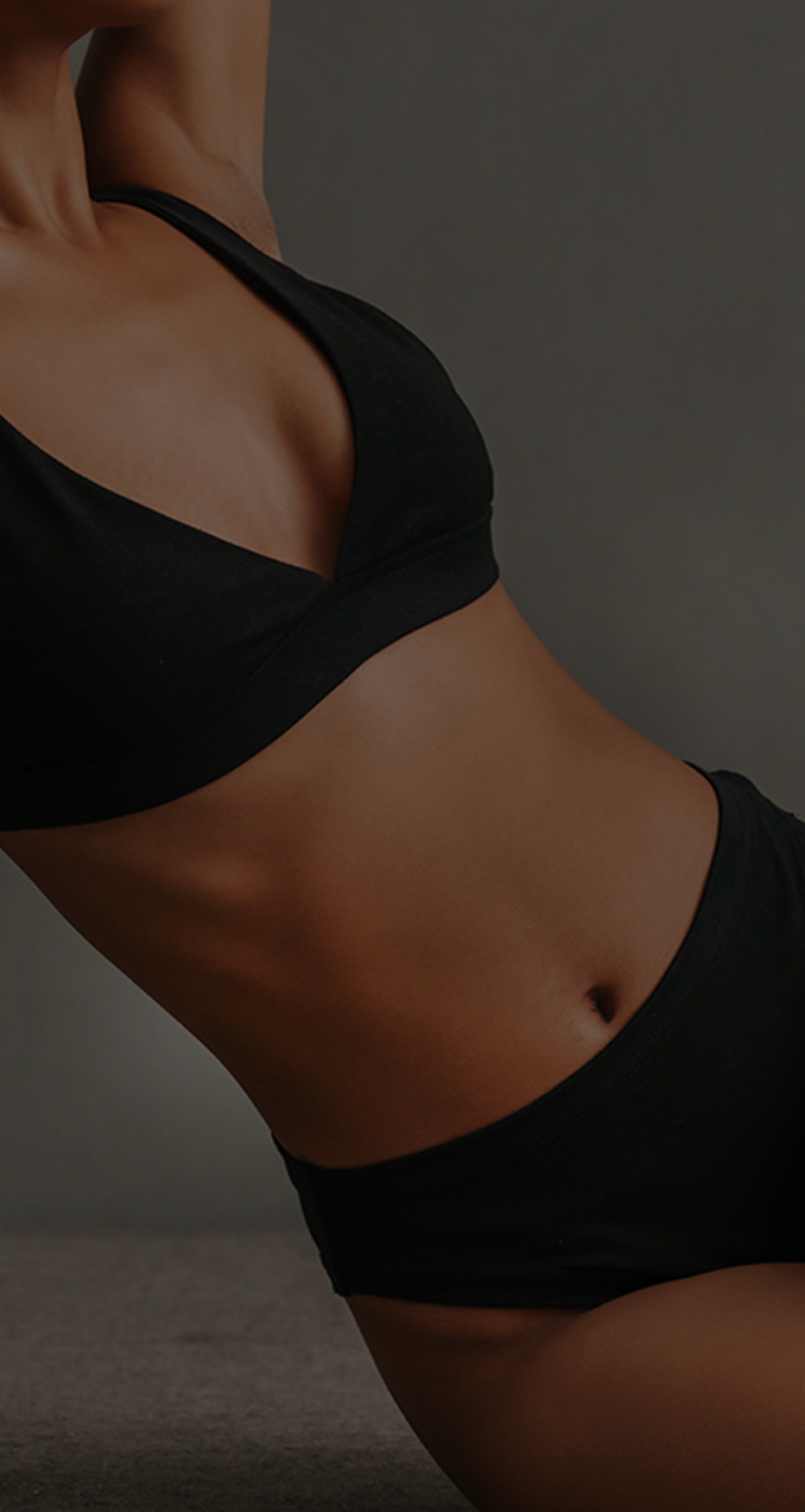 Woman in black bikini with gray background