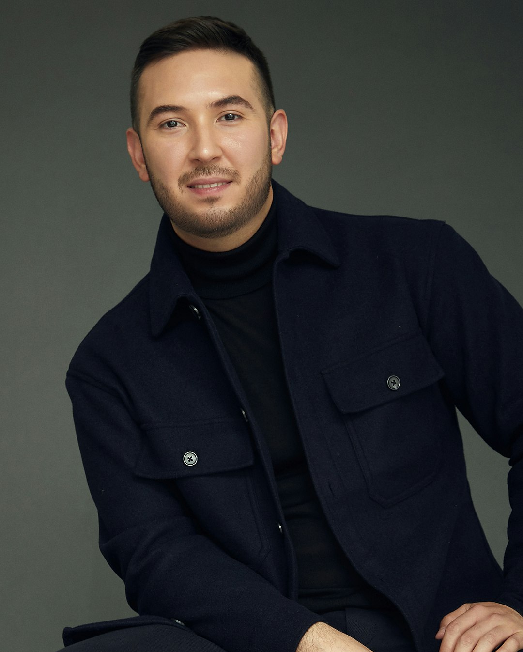 Man in a navy jacket and black turtle neck