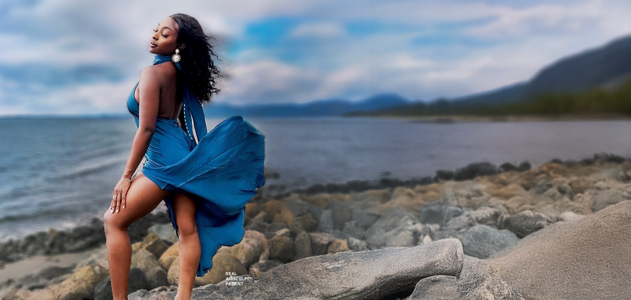 woman in blue dress facing the ocean