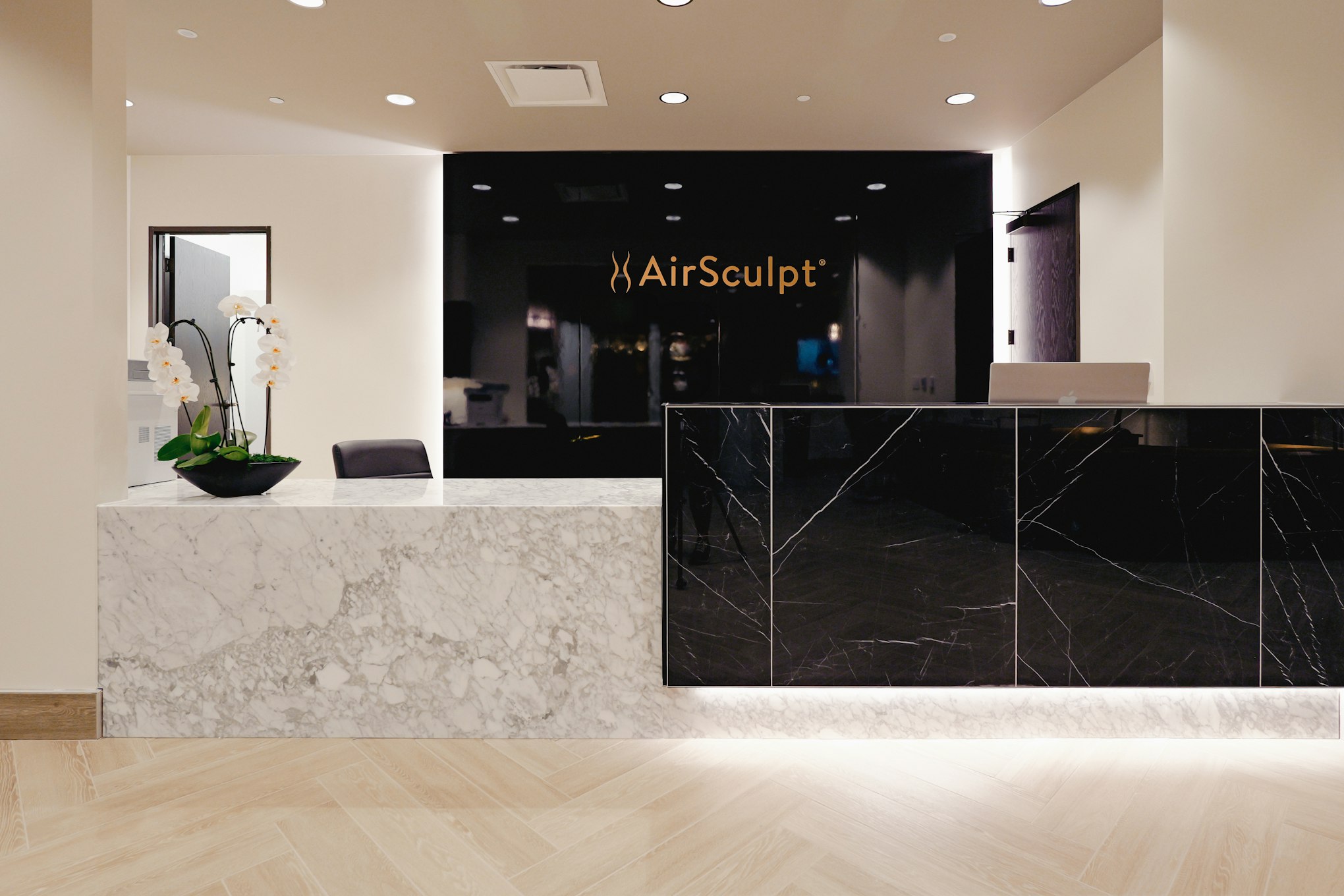 Front desk and backdrop featuring AirSculpt logo in AirSculpt Body Contouring Columbus clinic lobby