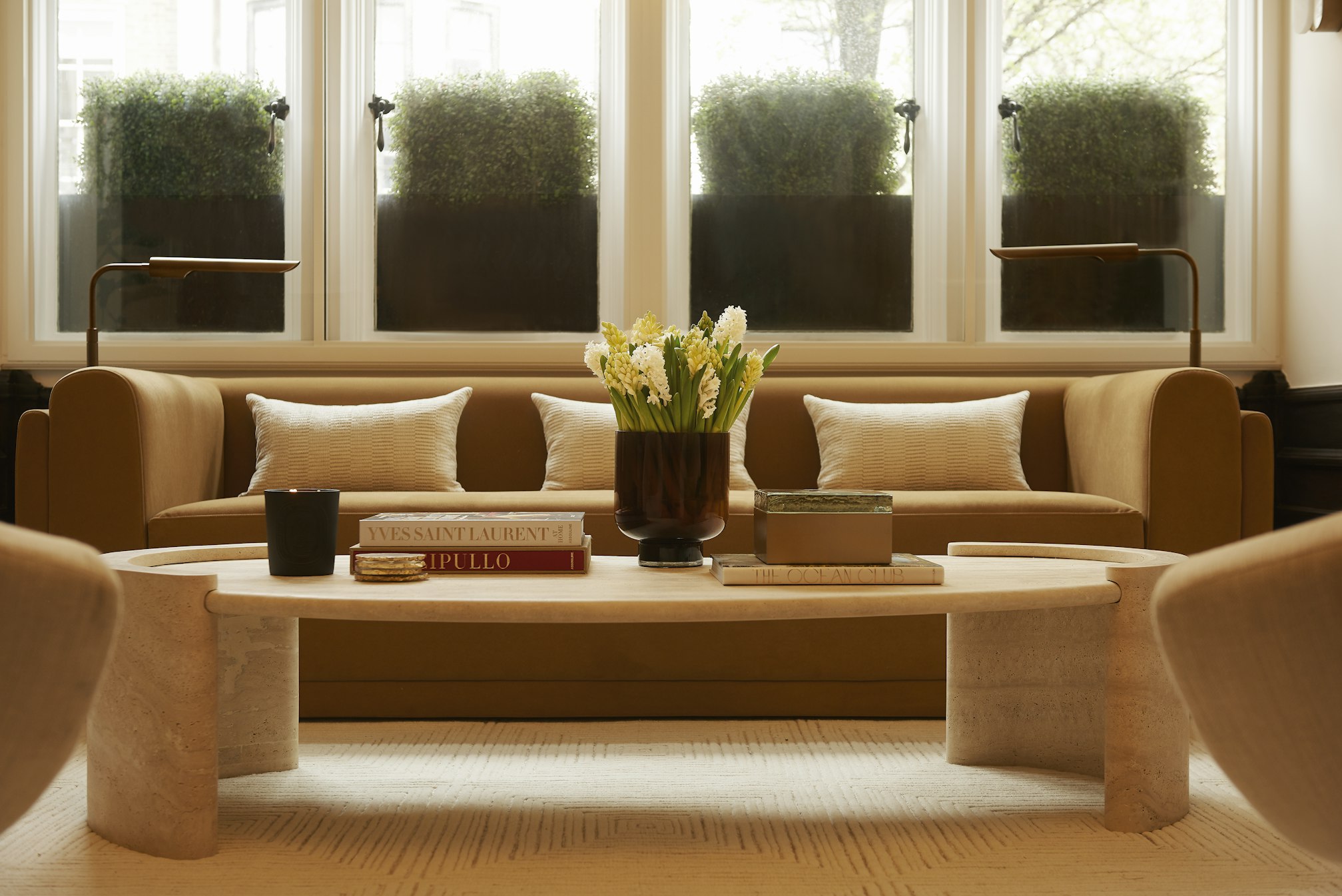 Couch, coffee table, and potted plants in Elite Body Sculpture London clinic waiting area
