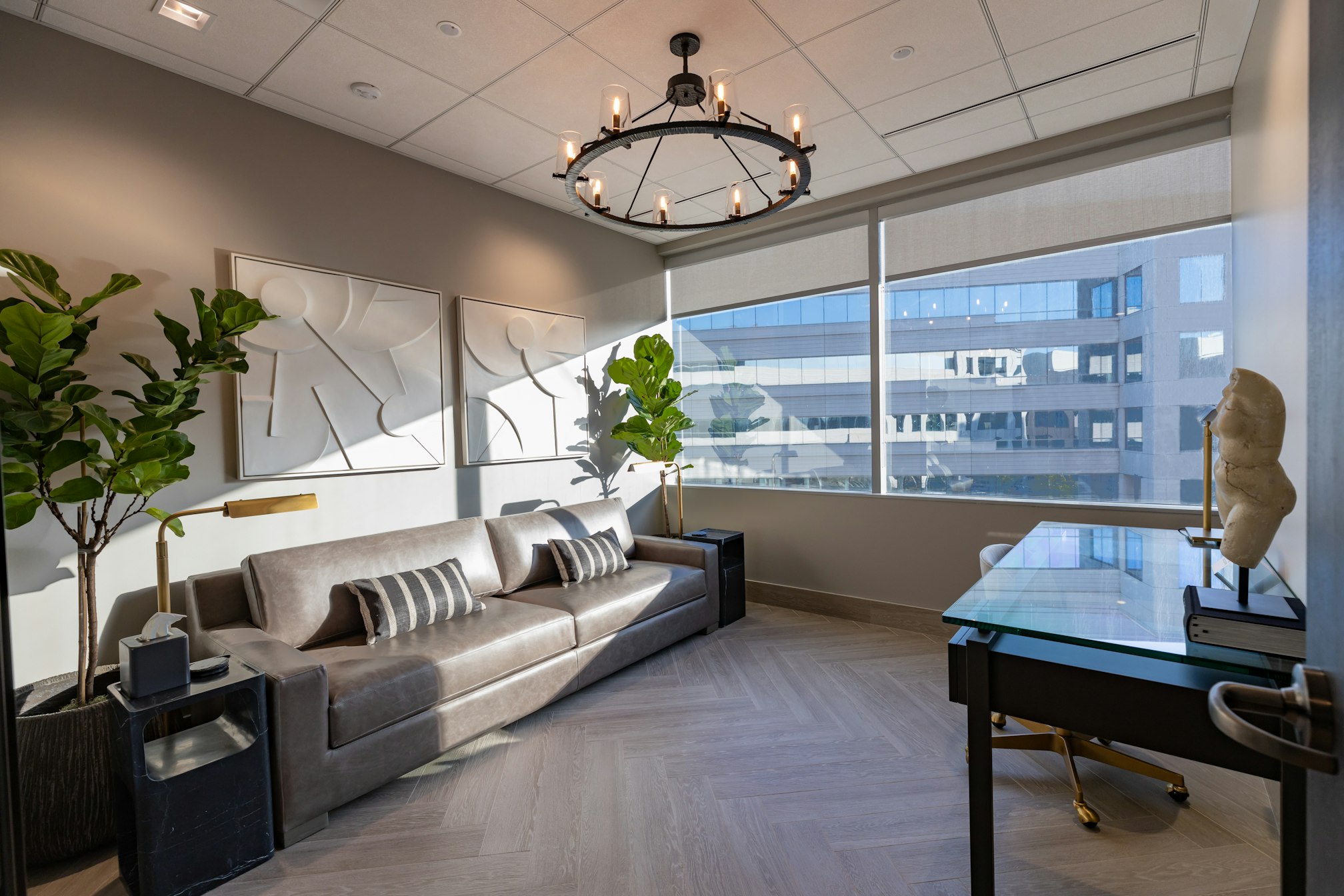 Couch and coffee table beneath chandelier in AirSculpt Body Contouring Orange County clinic consultation room