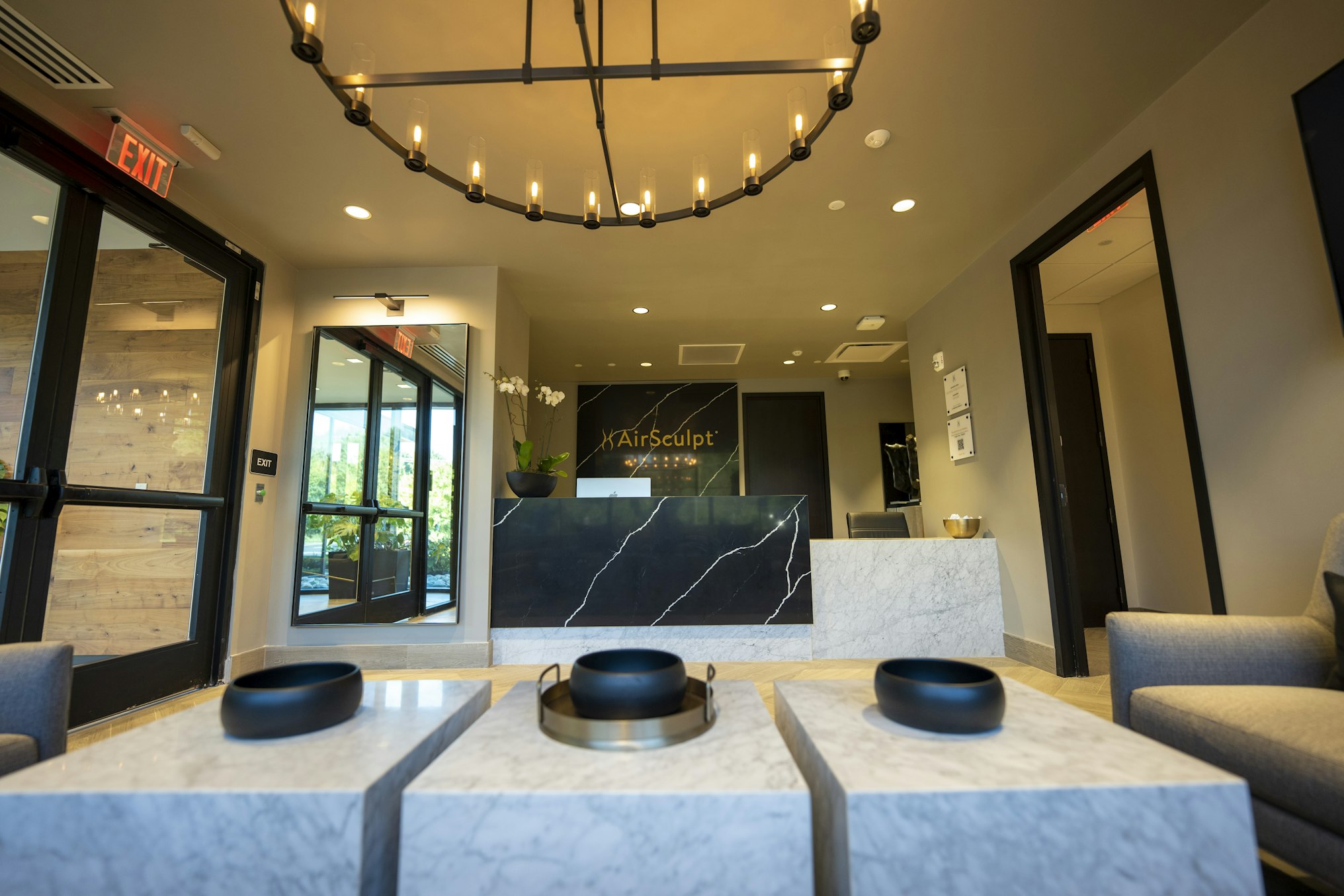 Lobby with chandelier, marbled tables, and front desk in AirSculpt Body Contouring Philadelphia clinic
