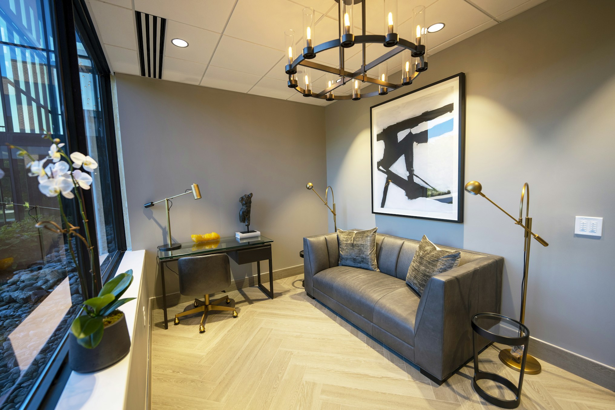 Consultation room with couch, desk, and chandelier in AirSculpt Body Contouring Philadelphia clinic