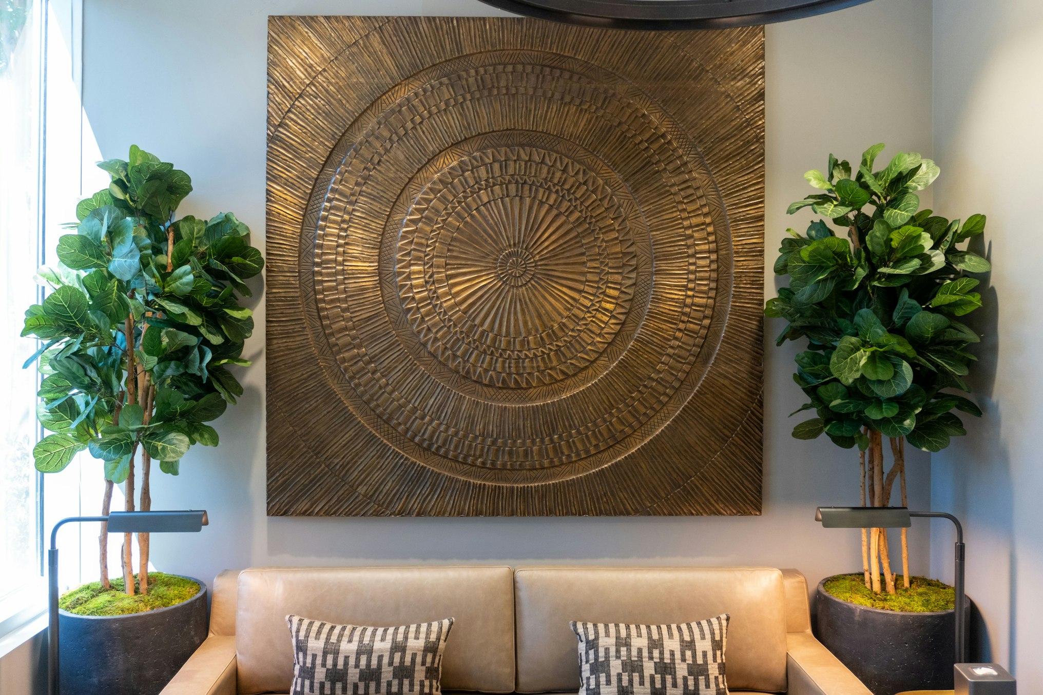 Wall art, couch, and potted plants in AirSculpt Body Contouring Raleigh clinic lobby